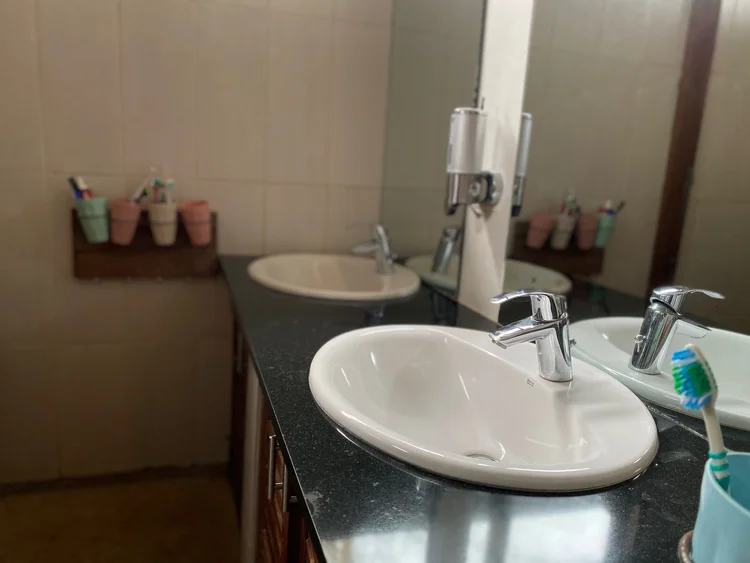 Dorm bathroom with sinks and children's toothbrush cups
