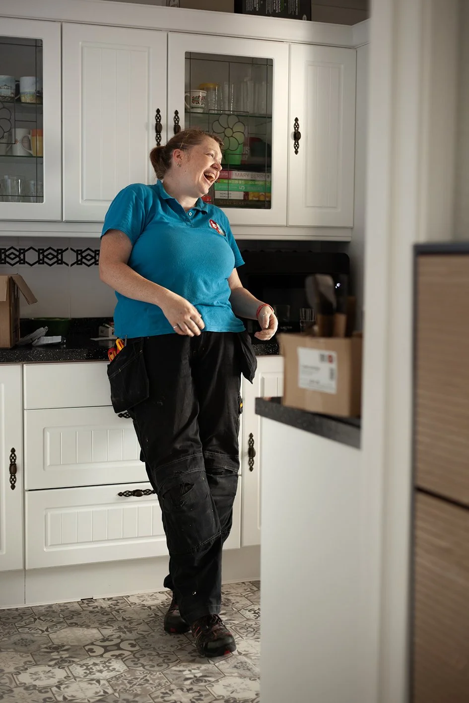 Checkatrade work. Anne, an electrician, at work at a domestic property. Anne talking to the customer. Epsom, Surrey. 2025.