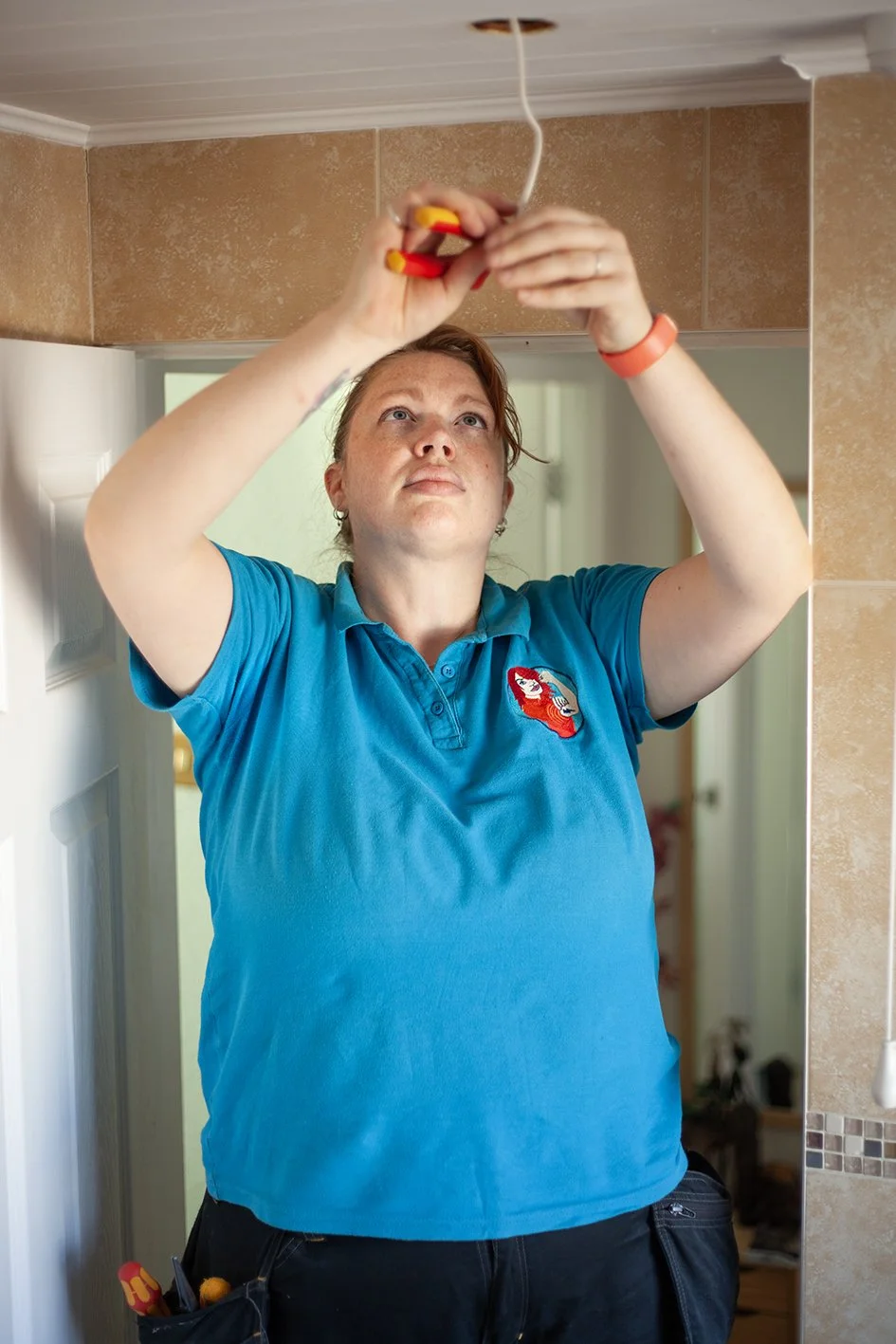 Checkatrade work. Anne, an electrician, at work at a domestic property. Epsom, Surrey. 2025.