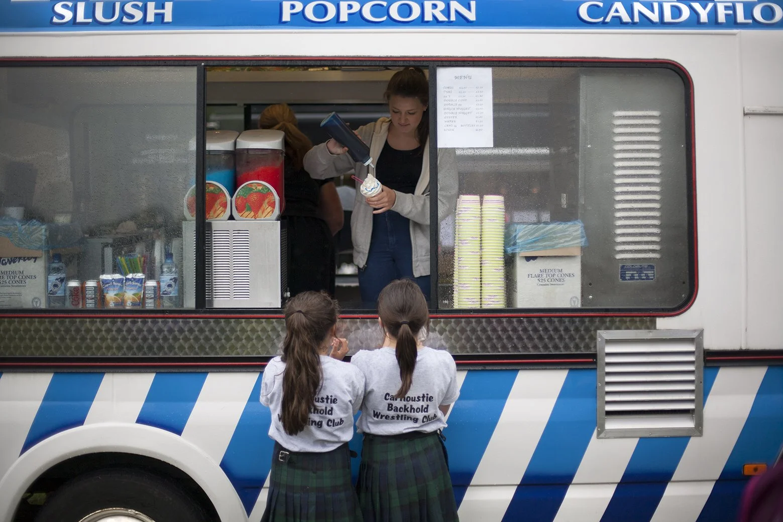 Young competitors getting an ice cream. Highland games, near Glasgow. Scotland. 2017.
