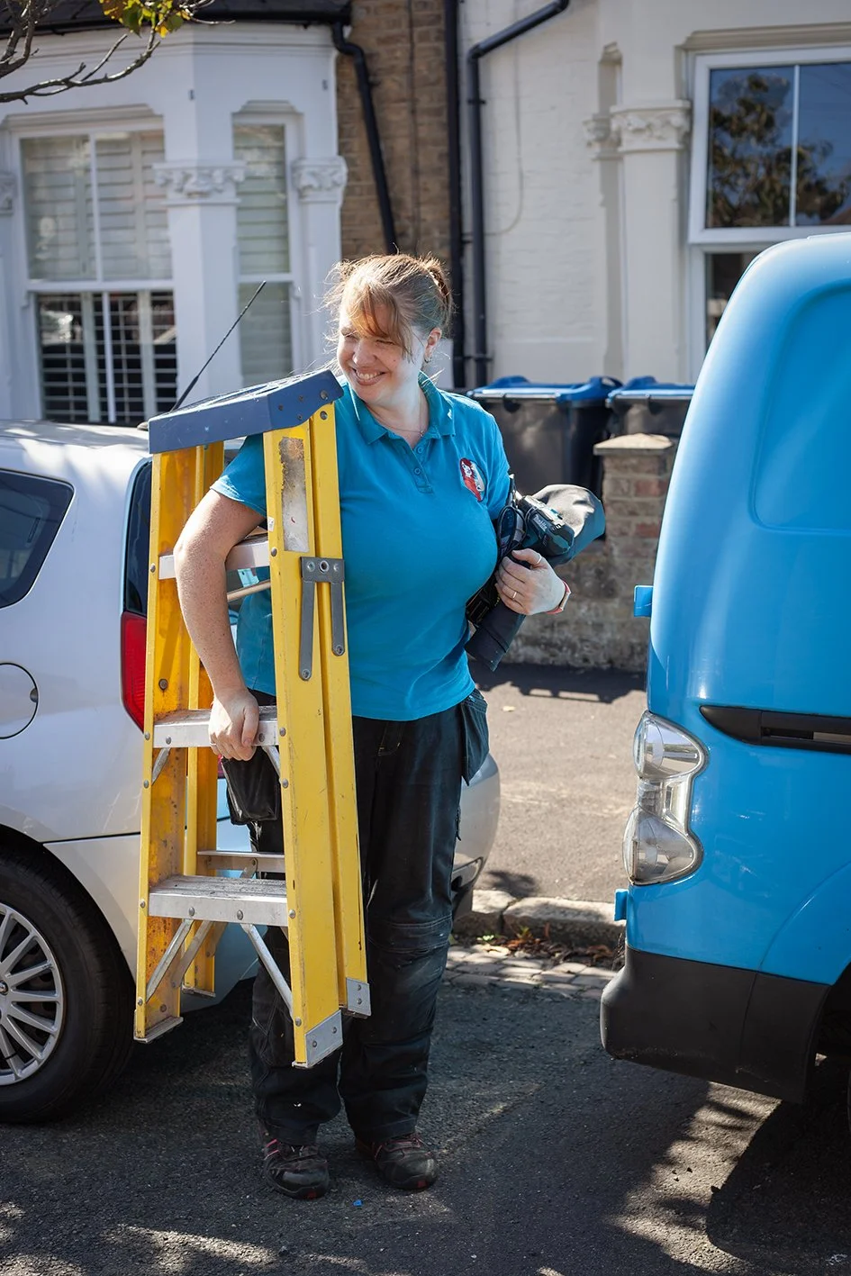 Checkatrade work. Anne, an electrician, at work at a domestic property. Anne arriving at a property. Wimbledon. 2025.