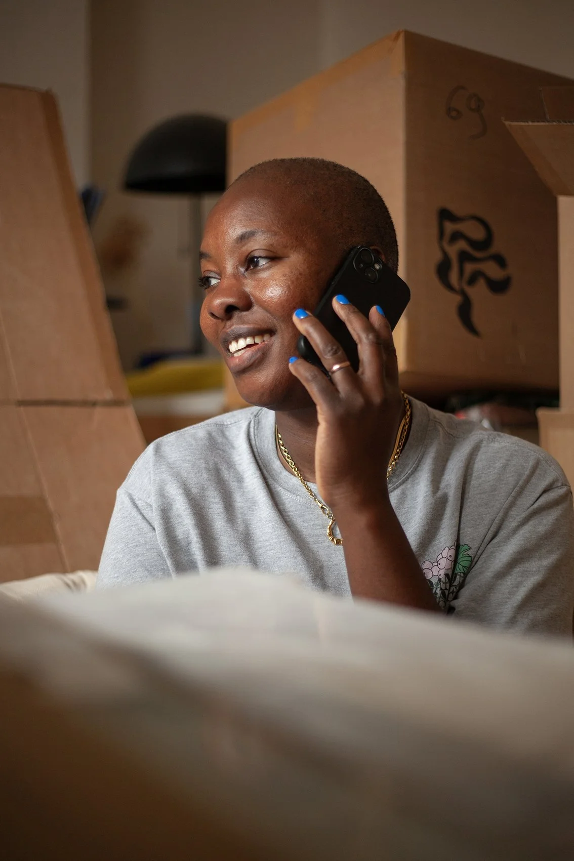 Checkatrade work. Styled shoot. Genuine customer at home surrounded by boxes, on the phone to Checkatrade. London.