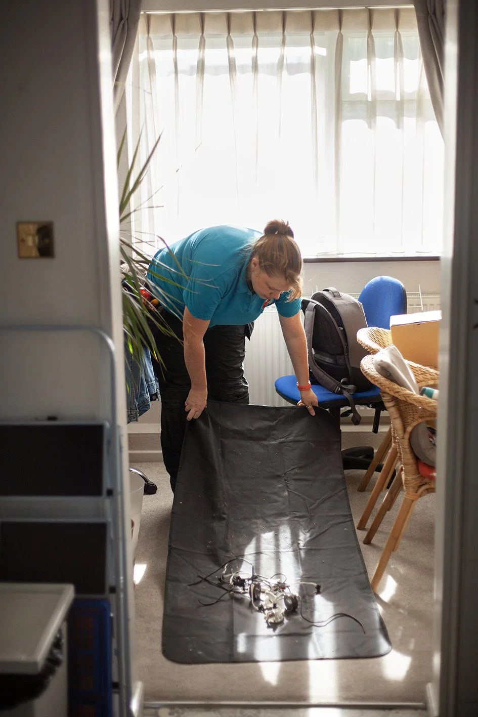 Checkatrade work. Anne, an electrician, at work at a domestic property. Epsom, Surrey. 2025.