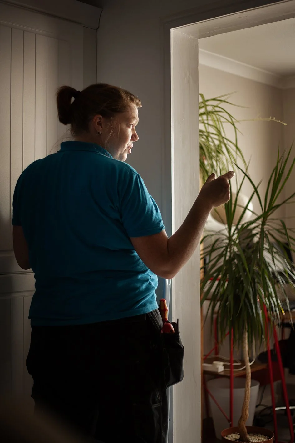 Checkatrade work. Anne, an electrician, at work at a domestic property.Anne talking to the customer. Epsom, Surrey. 2025.