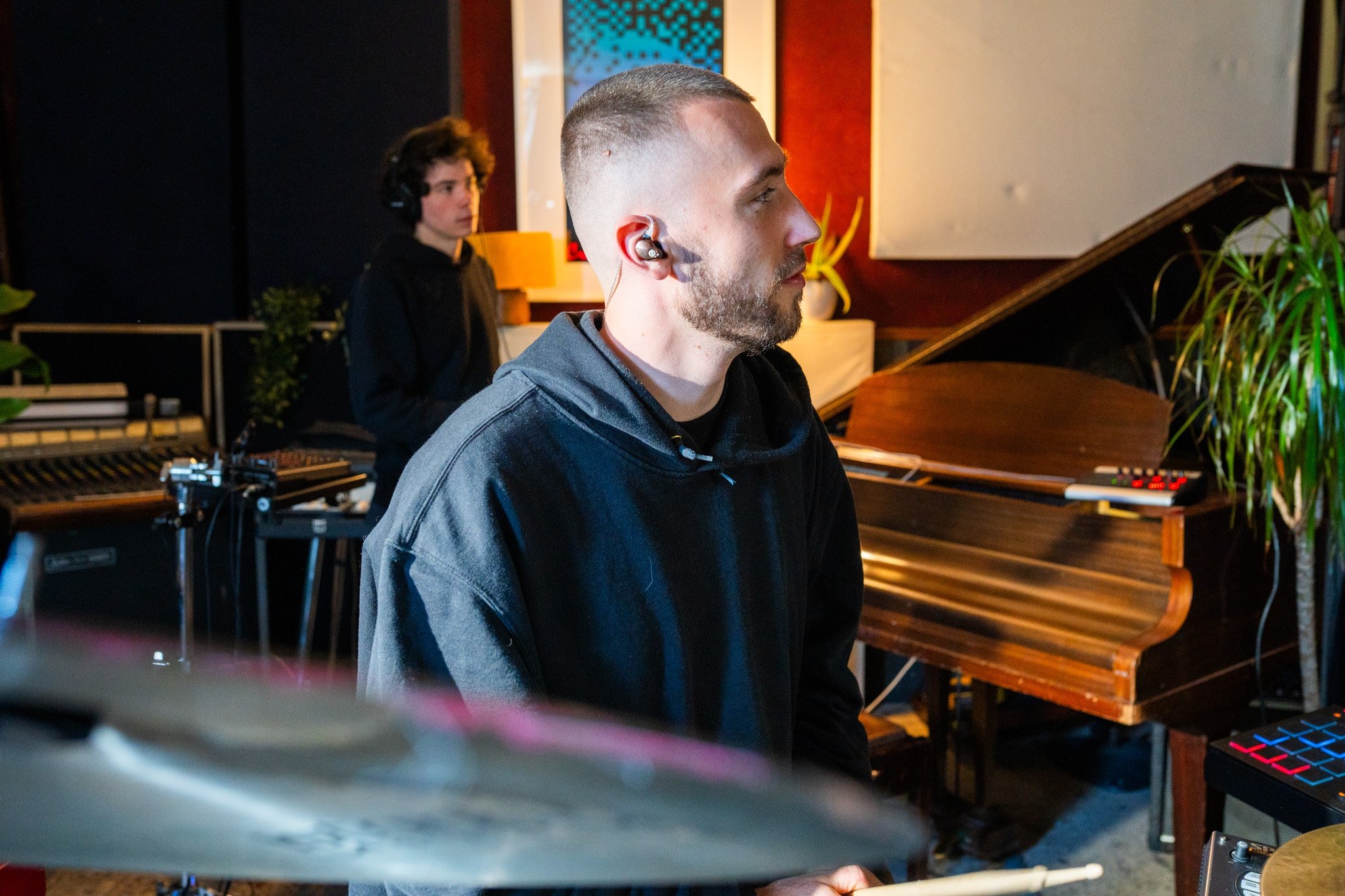 Musicians in a recording studio with ACS Eclipse 500 In Ear Monitors playing Drums.