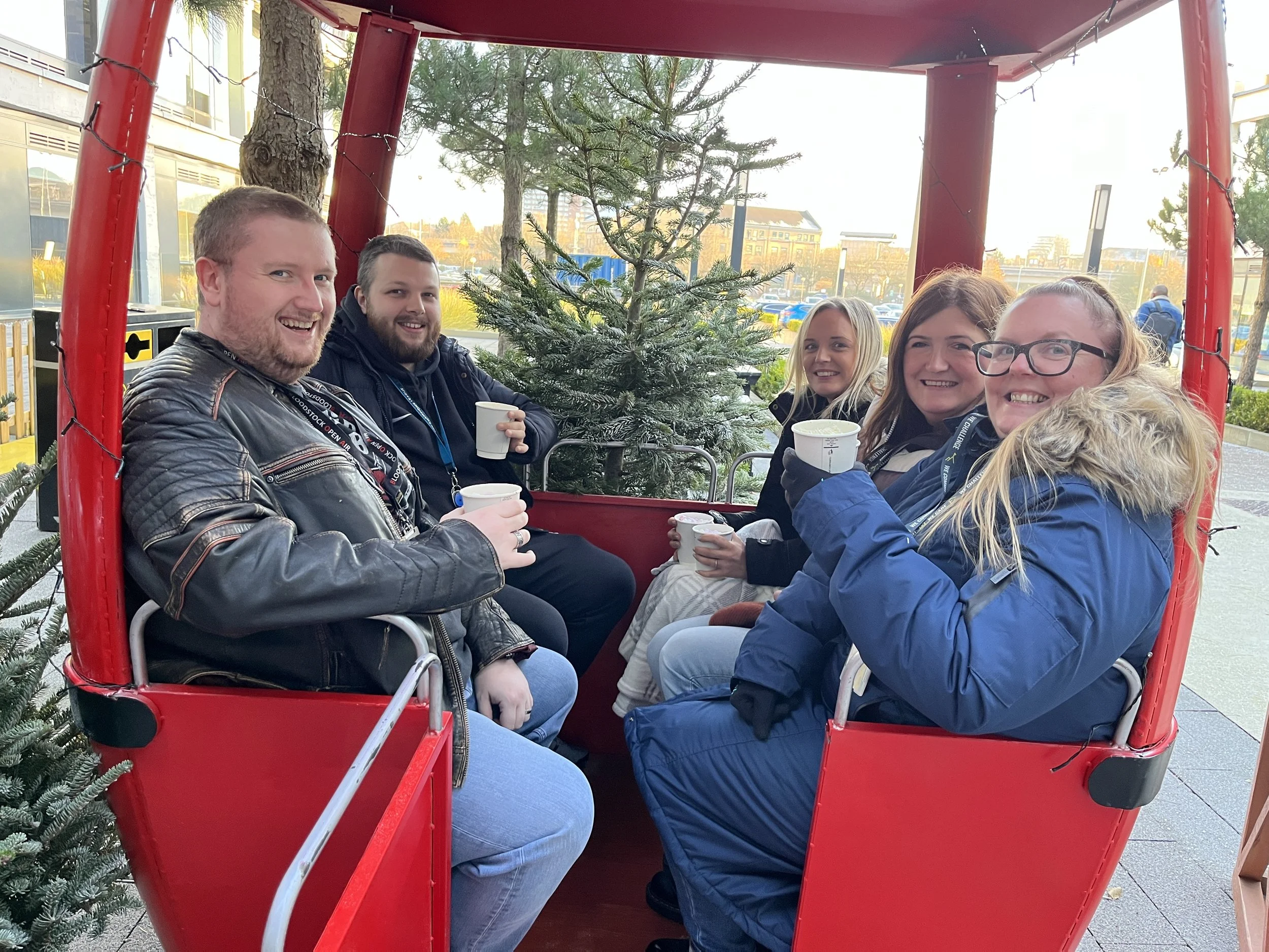 Team sitting in festive alpine scene drinking hot chocolate