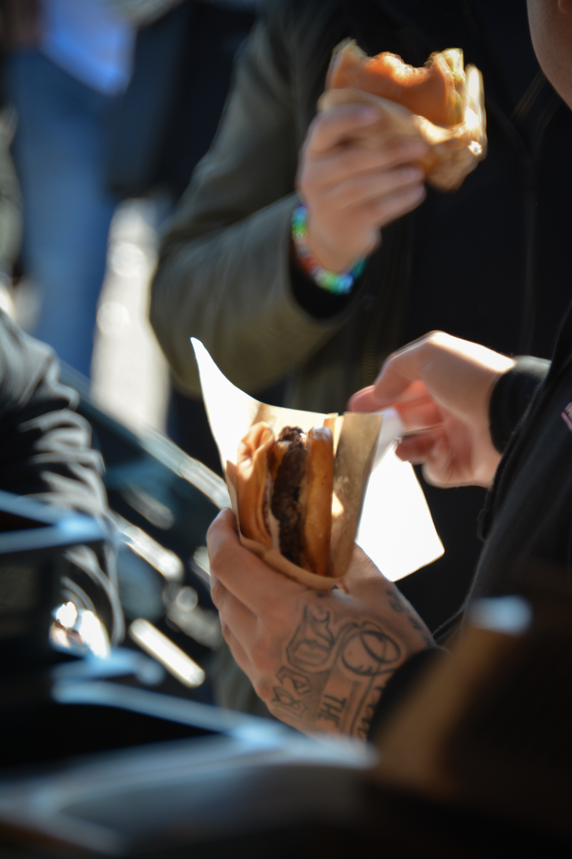 Person, der holder en burger, mens en anden person spiser en burger i baggrunden │Smash Burger Truck│Copenhagen│ København