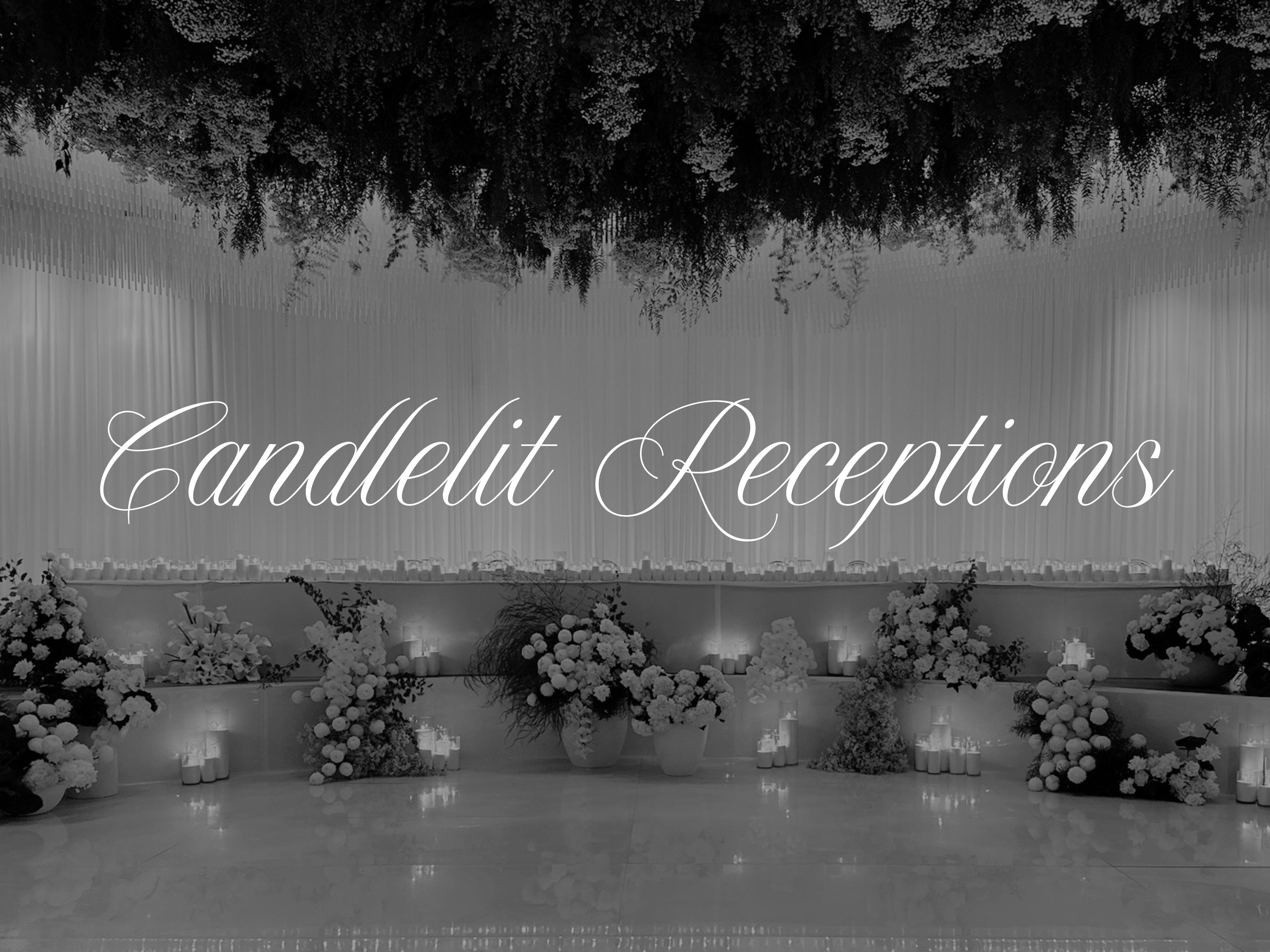 Elegant wedding reception setup with a large floral arrangement, candles, and draped fabric with the text 'Candlelit Receptions' written in cursive.