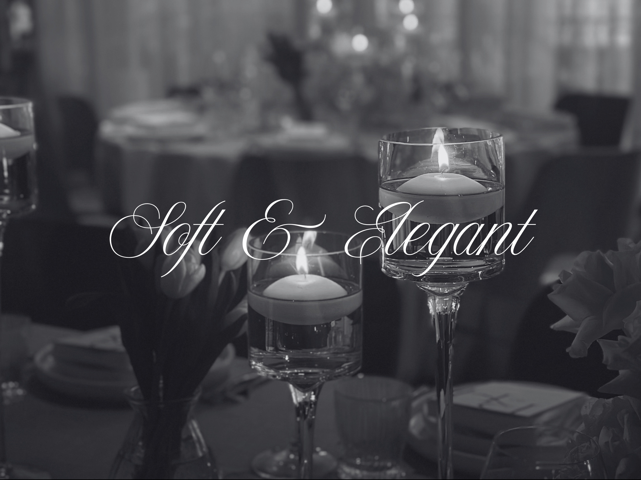 A close-up of a candle in a glass holder with other lit candles in the background, with the overlay text 'Soft & Elegant' in cursive.