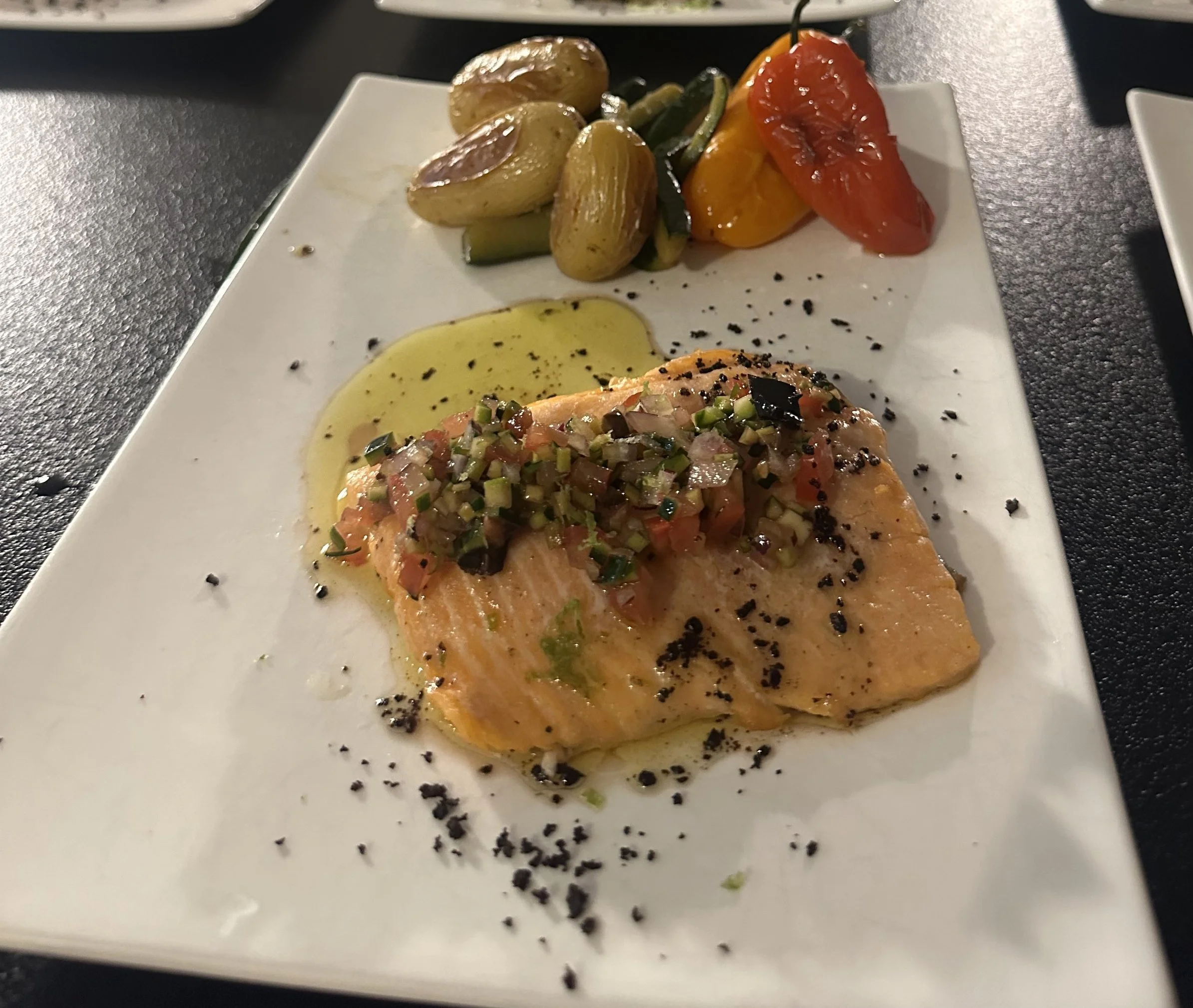 Filet de saumon avec salsa de tomates, concombre et oignons, accompagné de légumes grillés et d'une sauce à l'huile