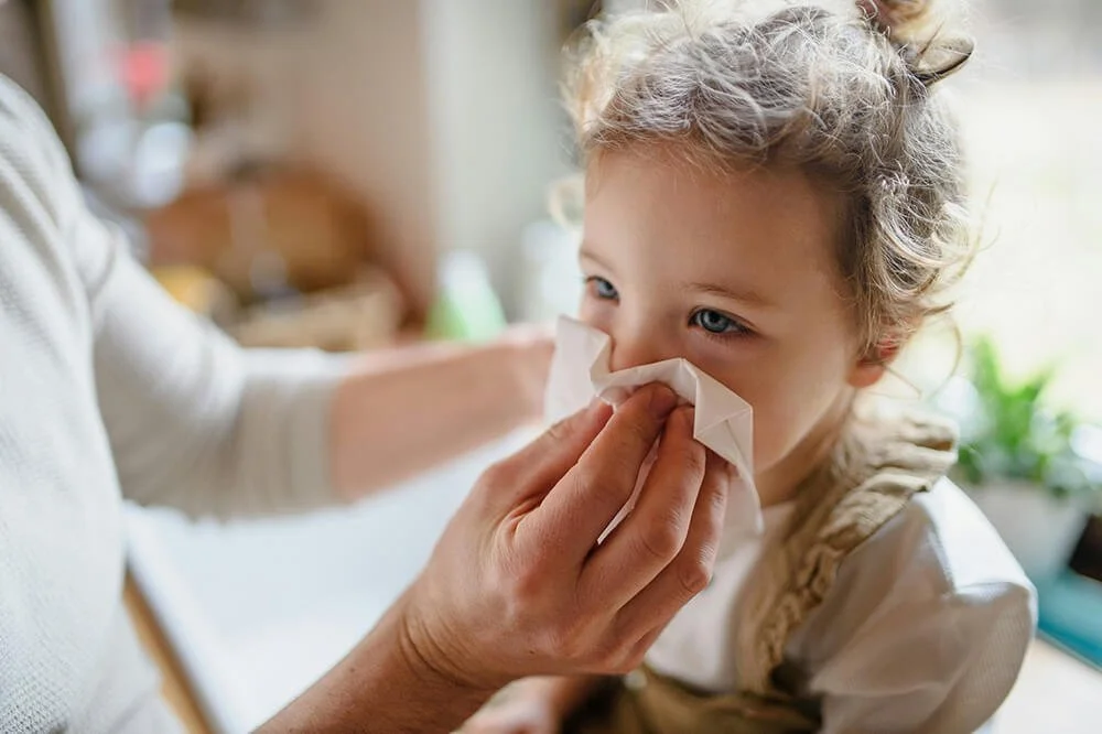 Child getting nose wiped and home remedies and holistic care with guides from Mother Earth Mama