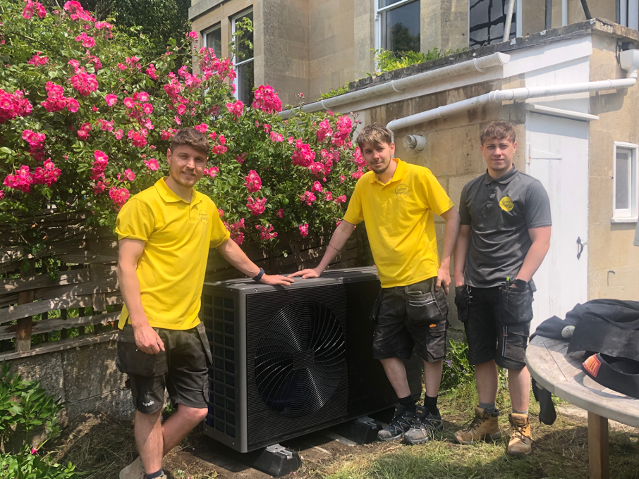Three installers from Good Energy with a new heat pump installation outside a Bath historic house