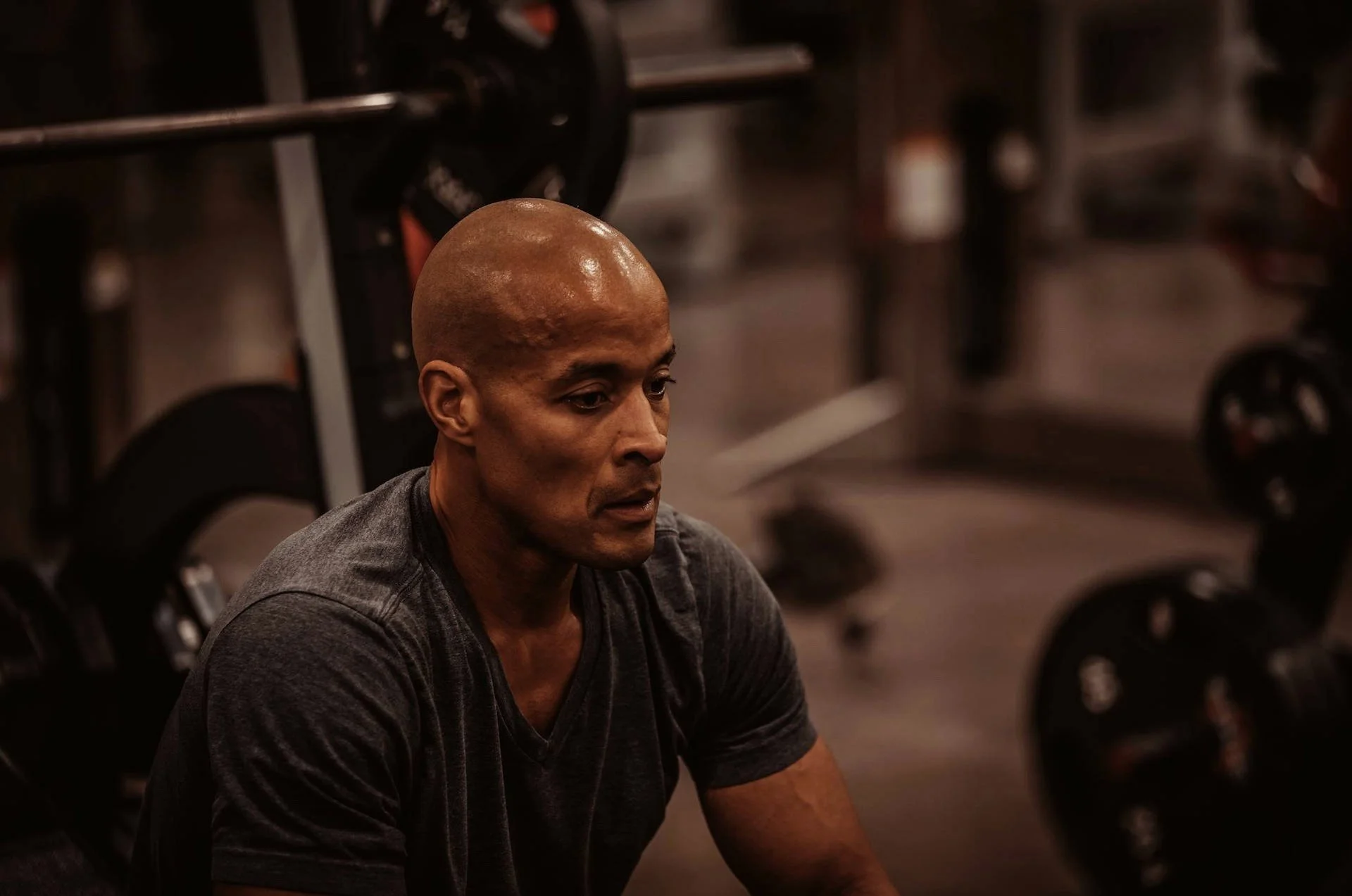 David Goggins in gym near weights carrying logs