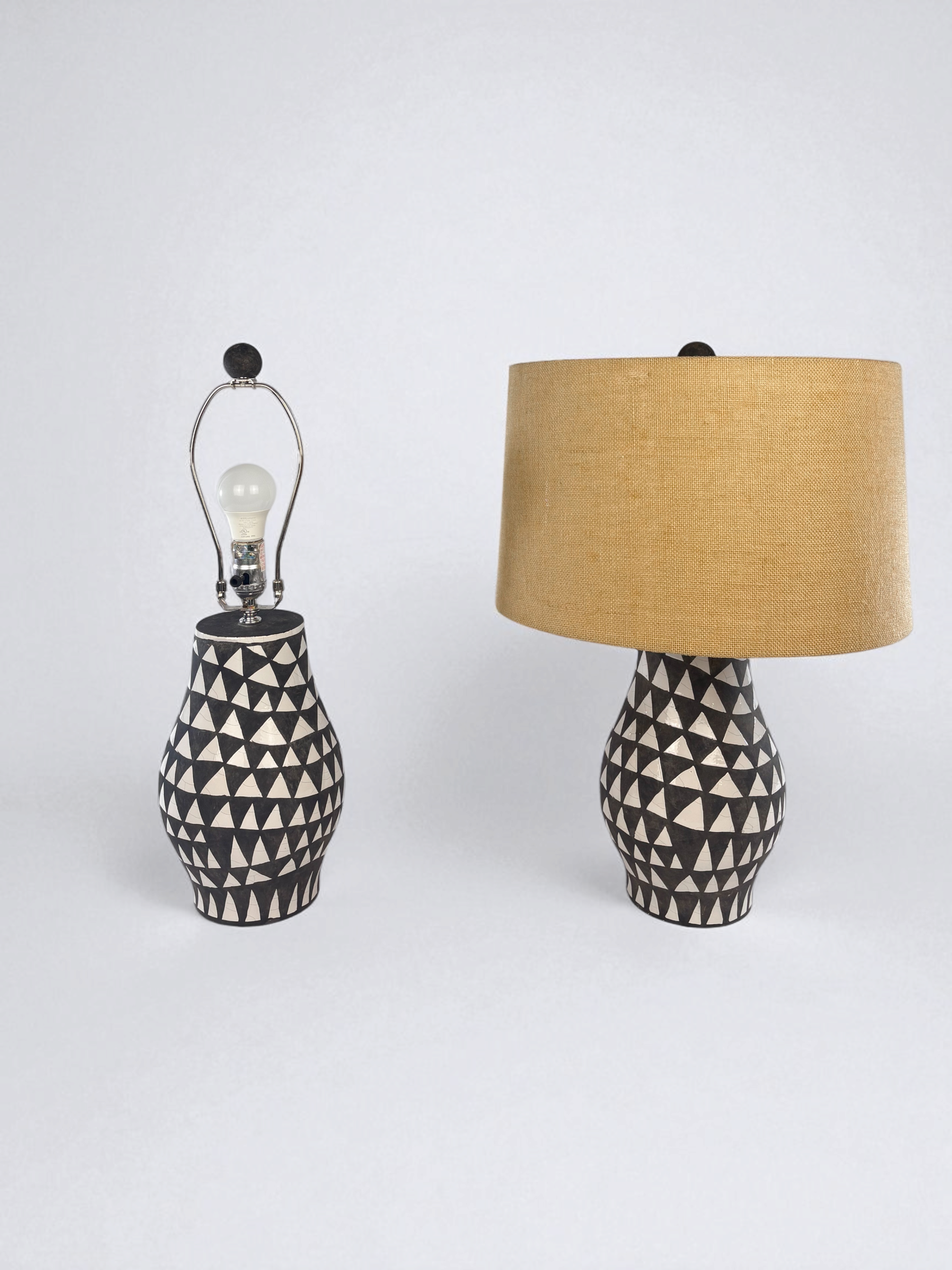 Image of two, pre-owned, black and white earthenware table lamps with jute lampshades.