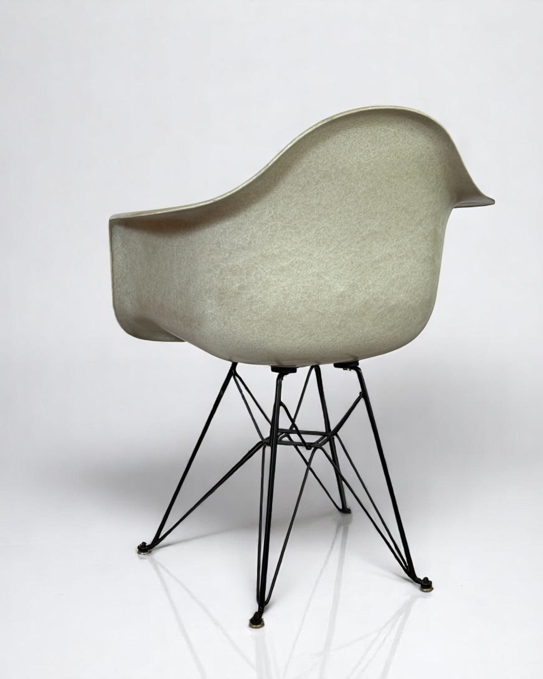 Modernica Case Study Furniture Arm Shell Eiffel chair, pre-owned, in color natural, with black metal base.