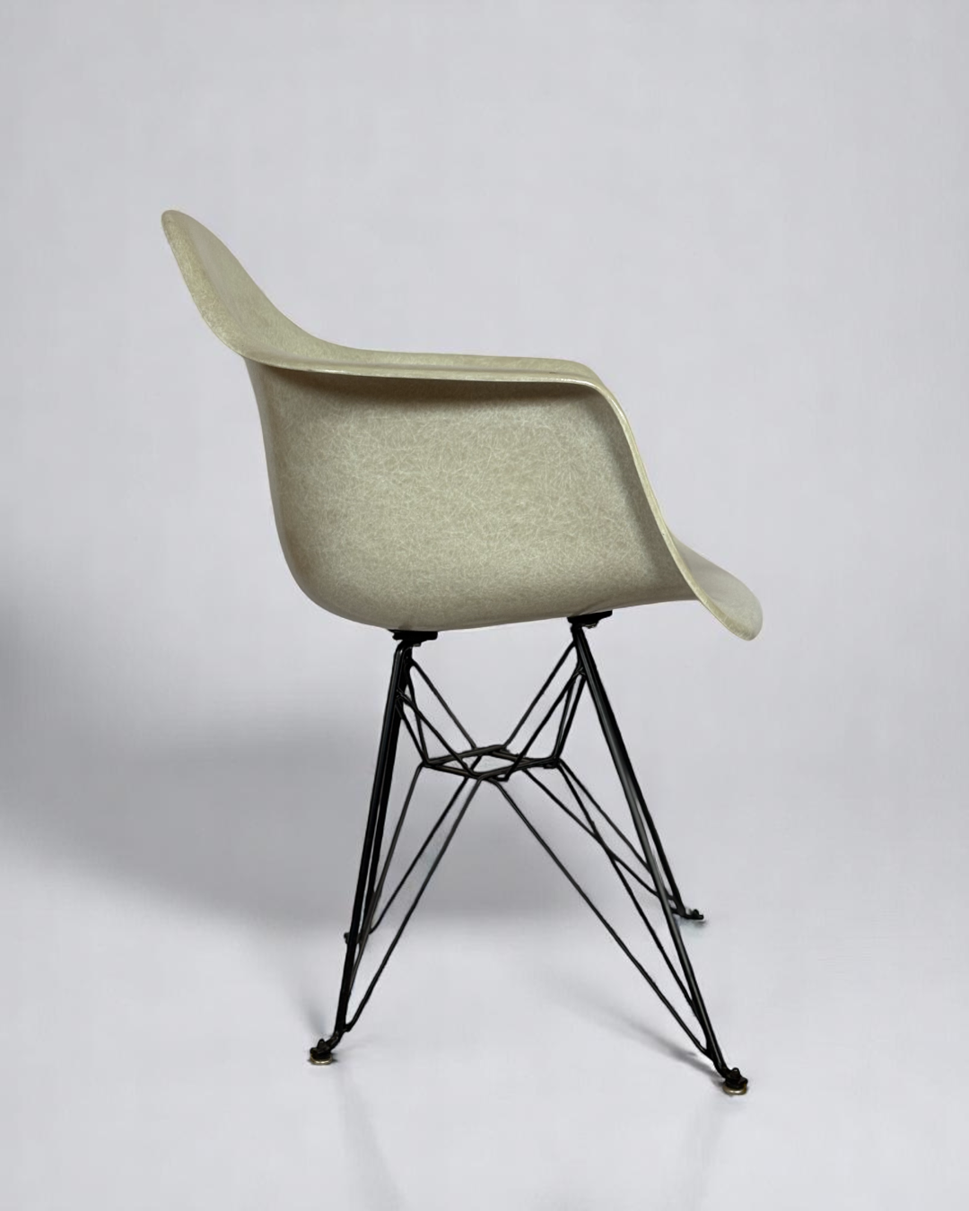 Modernica Case Study Furniture Arm Shell Eiffel chair, pre-owned, in color natural, with black metal base.
