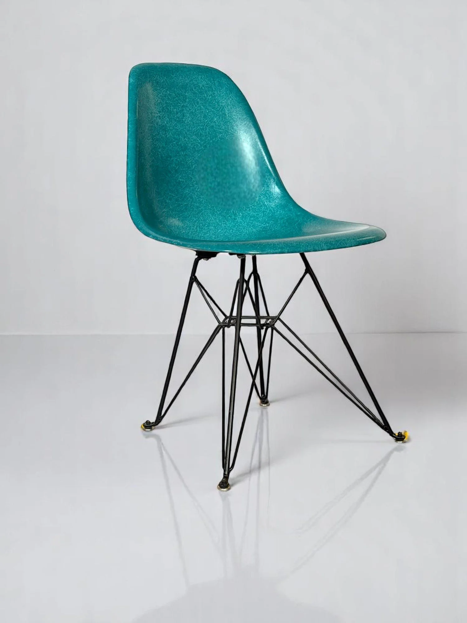 Pre-owned, Modernica Case Study Furniture Side Shell Eiffel chairs in color peacock with black metal base.