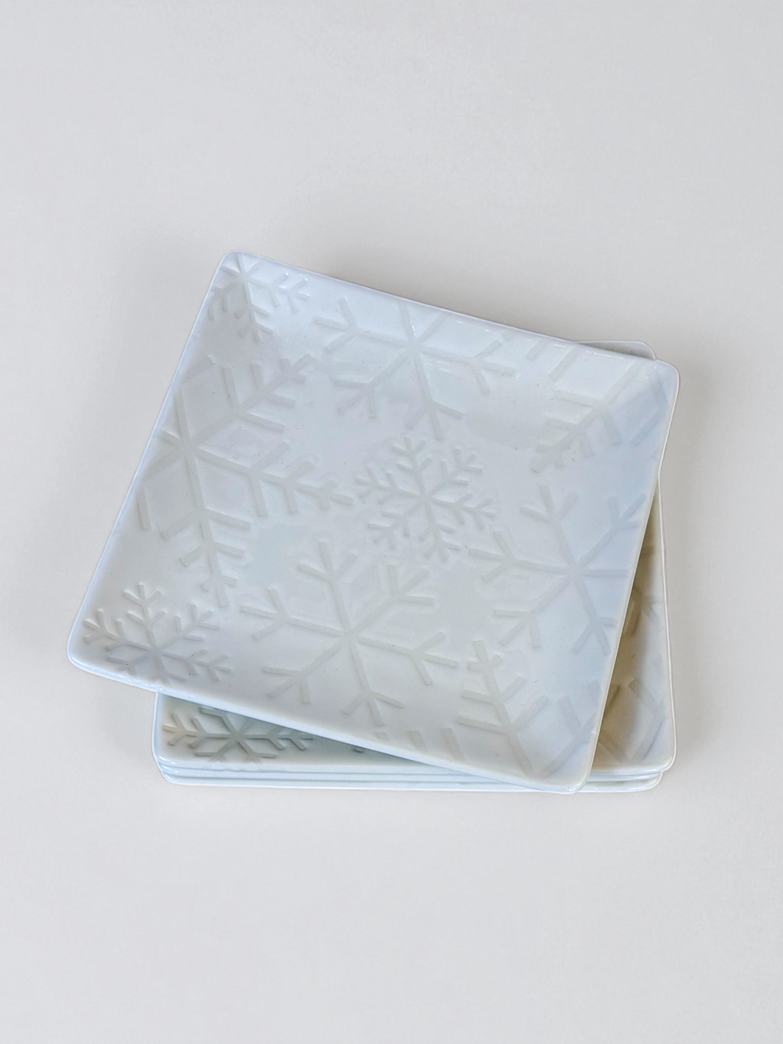Set of 4 white snowflake embossed plates by Crate & Barrel, pre-owned.