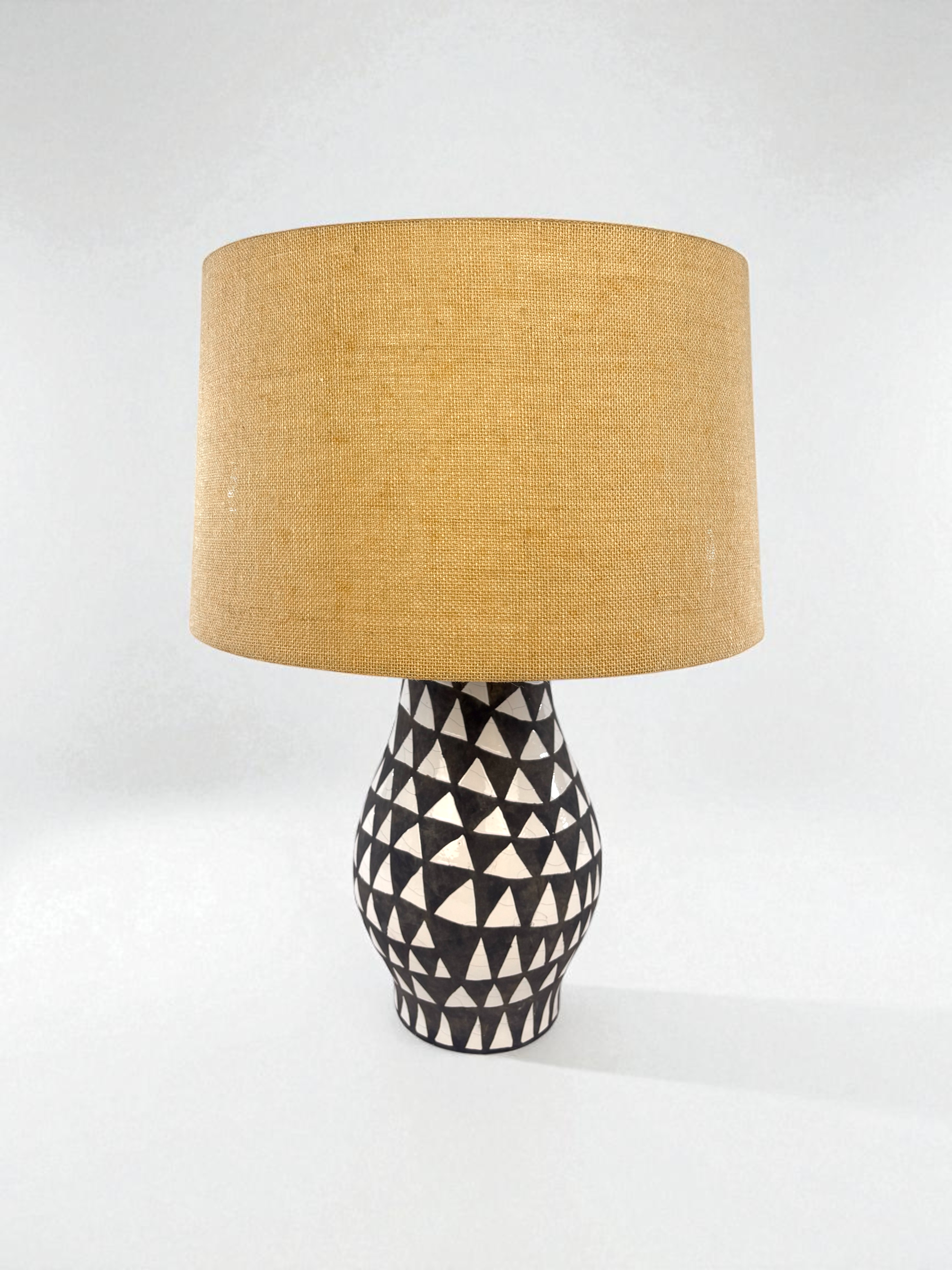 Image of two, pre-owned, black and white earthenware table lamps with jute lampshades.