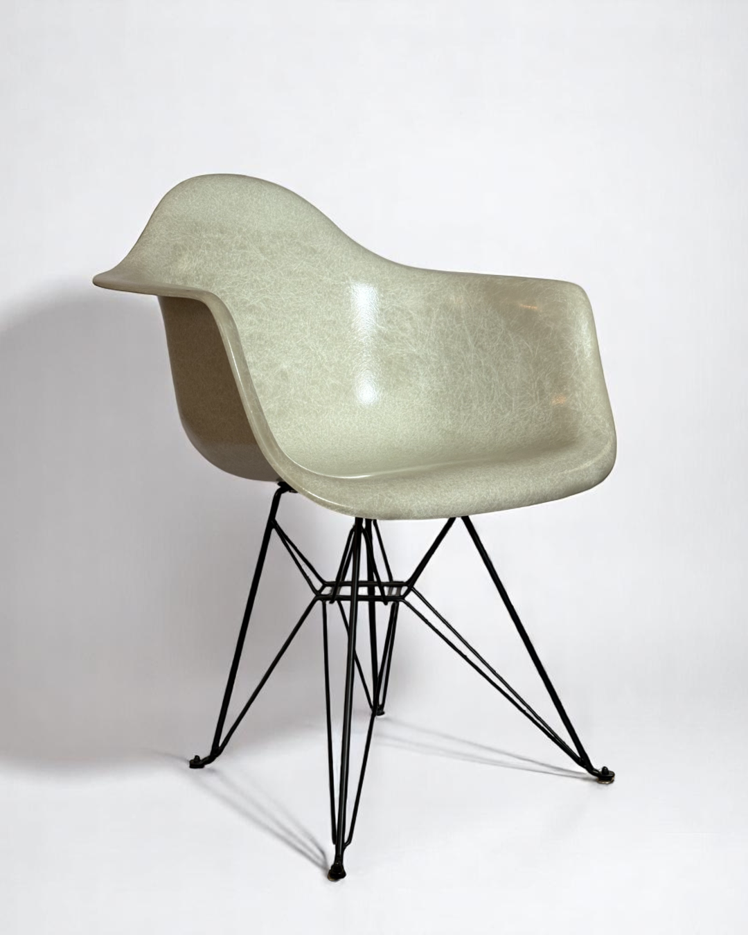 Modernica Case Study Furniture Arm Shell Eiffel chair, pre-owned, in color natural, with black metal base.