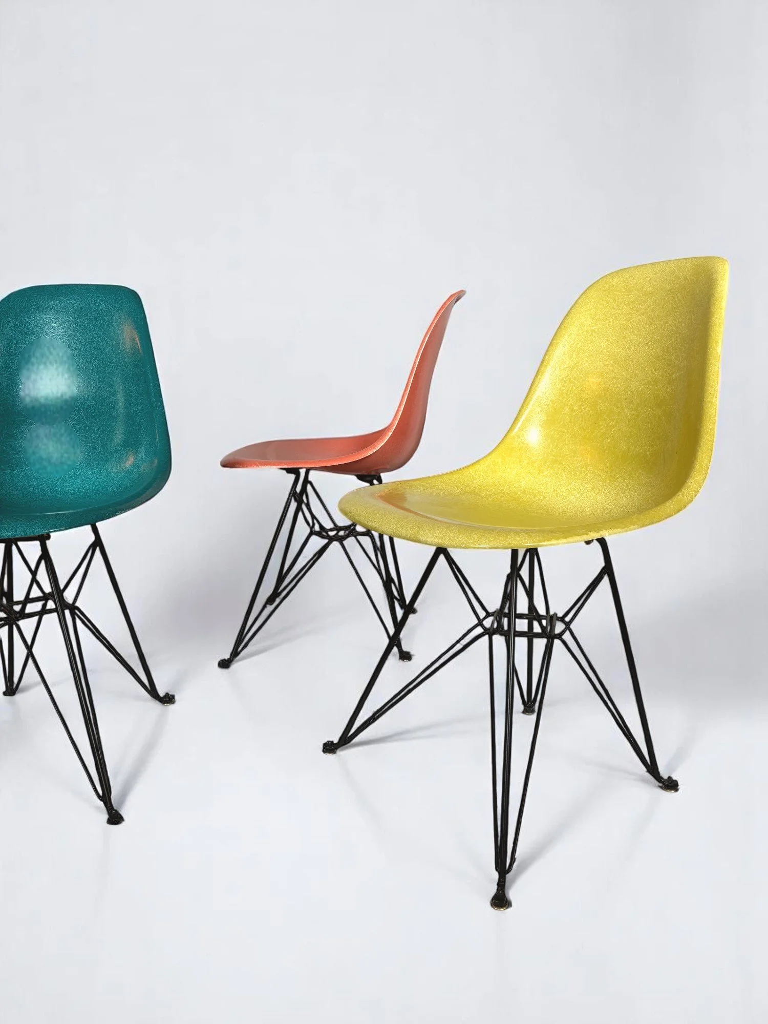 Pre-owned, Modernica Case Study Furniture Side Shell Eiffel, set of 4 chairs in colors pickle, coral, peacock, and pumpernickel with black metal bases.