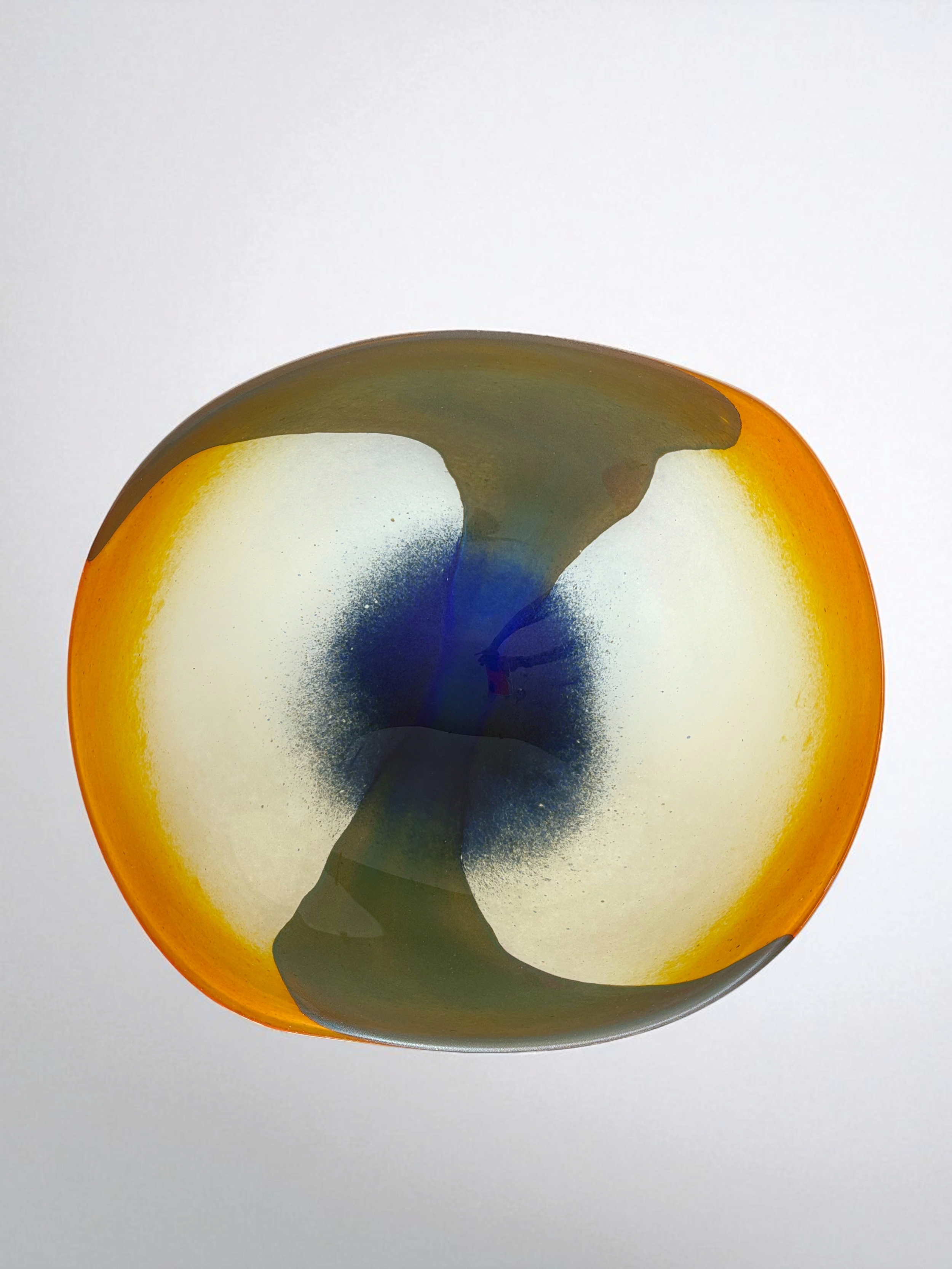 Image of handblown european art glass low bowl/plate. Colors are orange, white, navy and olive green produced in a style similar to nuvo Lithuania.