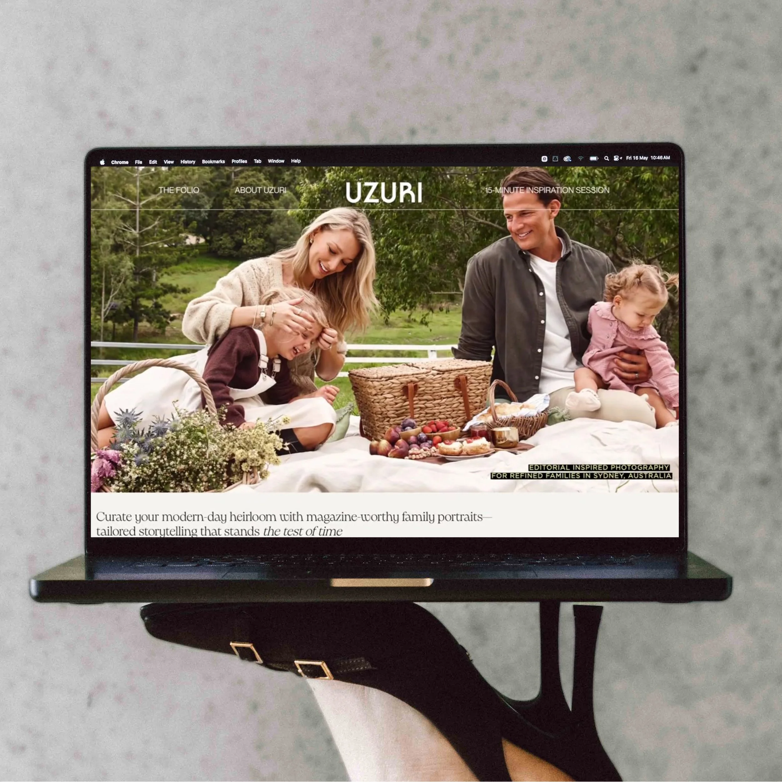 Laptop displaying a family picnic scene with two women, a man, and two young children outdoors in a park, with a picnic blanket and basket.