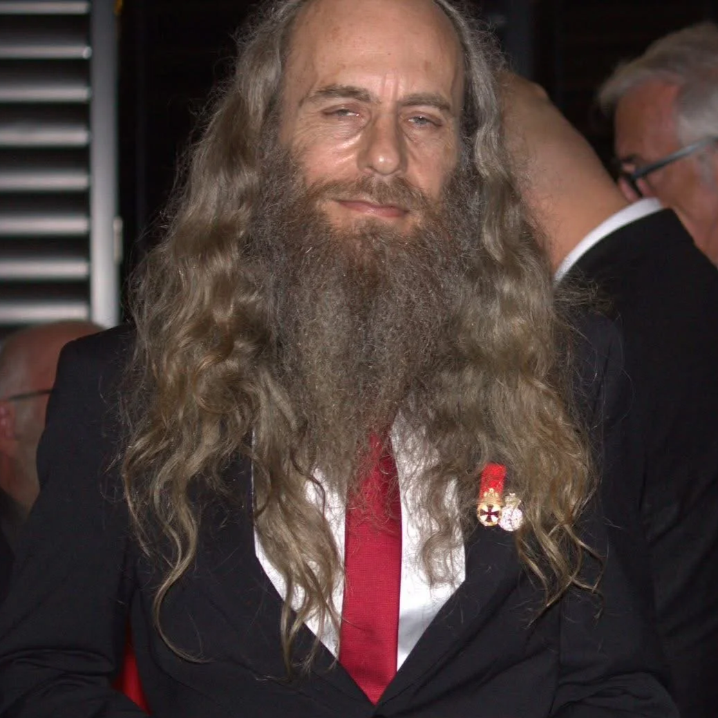 Detailed heraldic coat of arms featuring a crown, two angels with shields, flags, and a banner with Latin text 'non nobis domim'e.