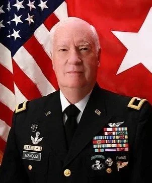 A man in a military uniform standing in front of American and Turkish flags.