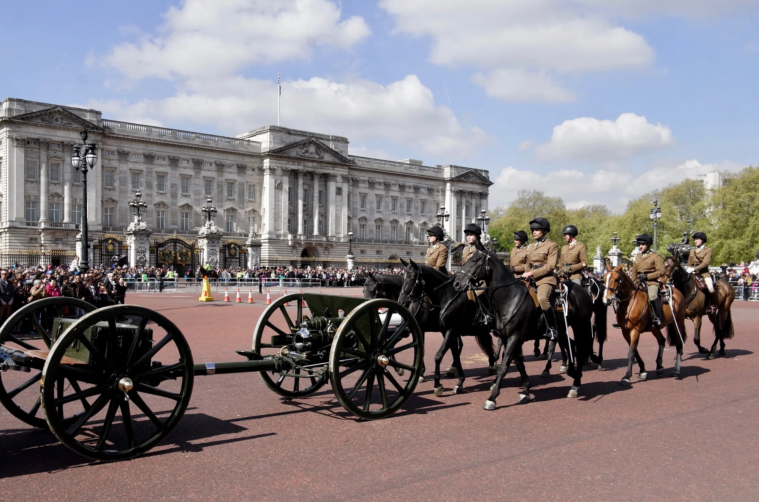 Mounted police officers in uniform riding horses in front of Buckingham Palace during Changing the Guard