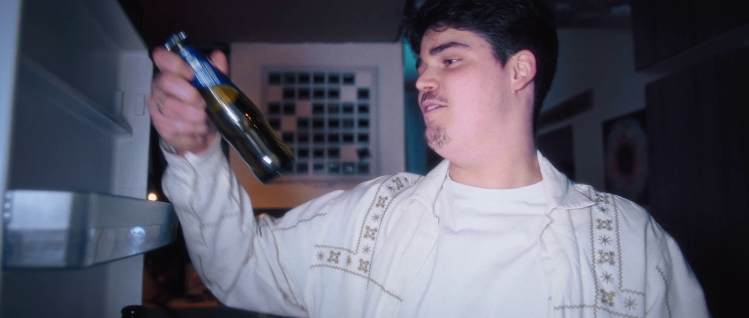Un homme verse une boisson dans un verre dans une cuisine