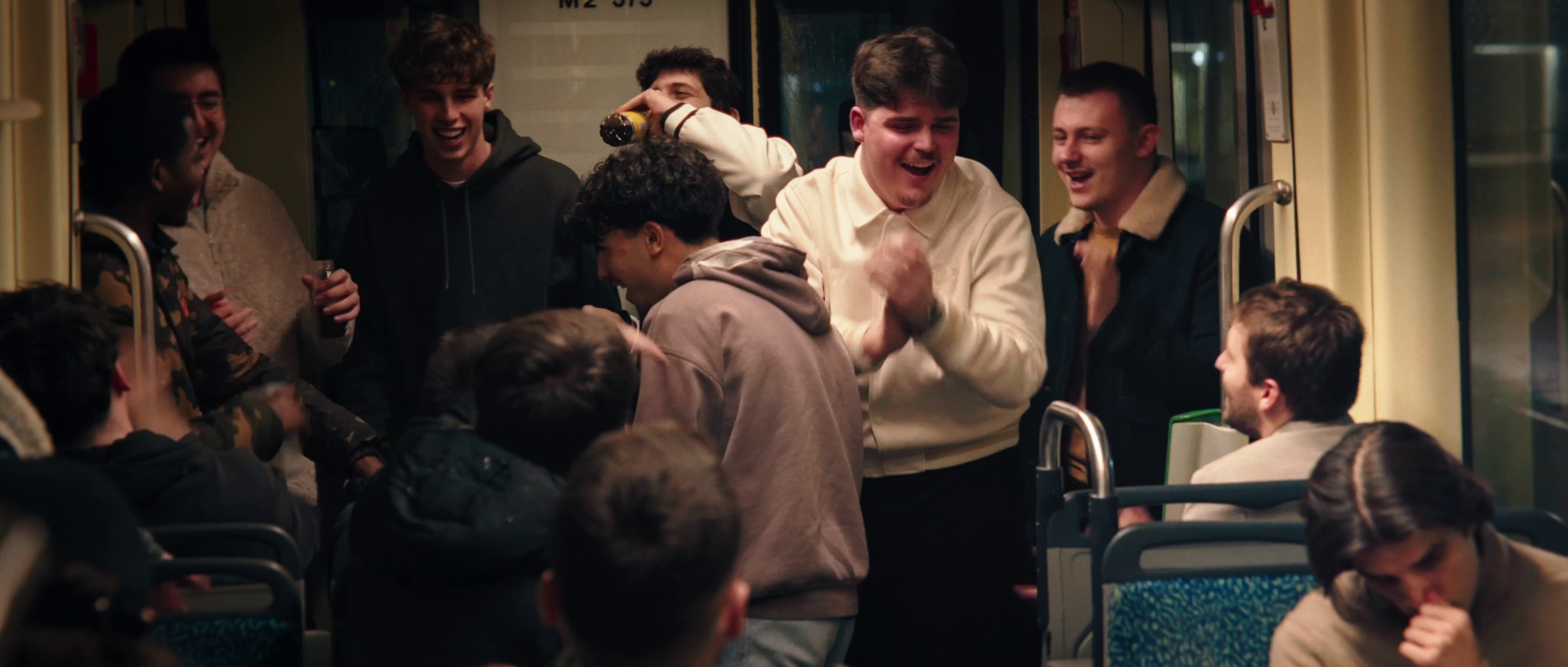 Groupe d'adolescents riant et discutant à l'intérieur d'un bus, certains assis, d'autres debout.