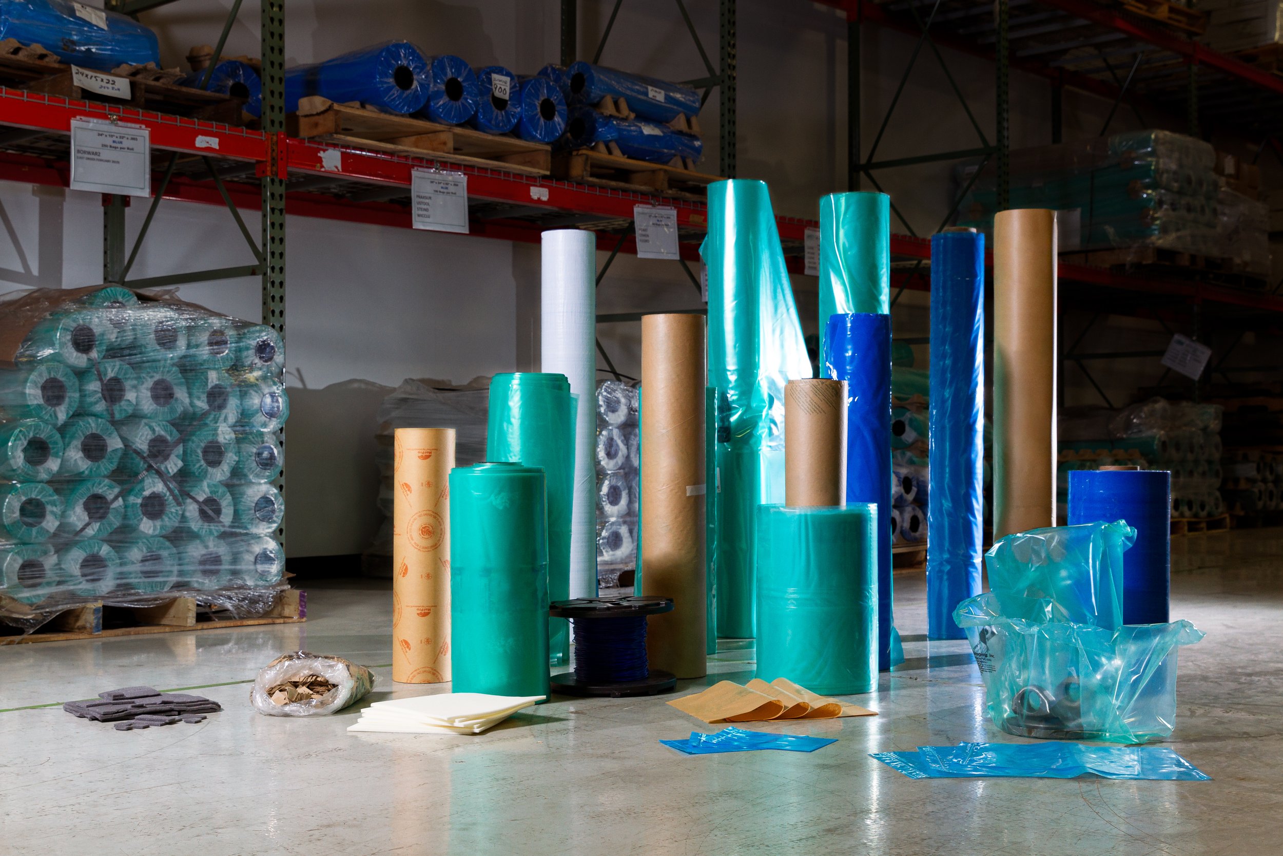 Various rolls of industrial packaging materials in a warehouse.