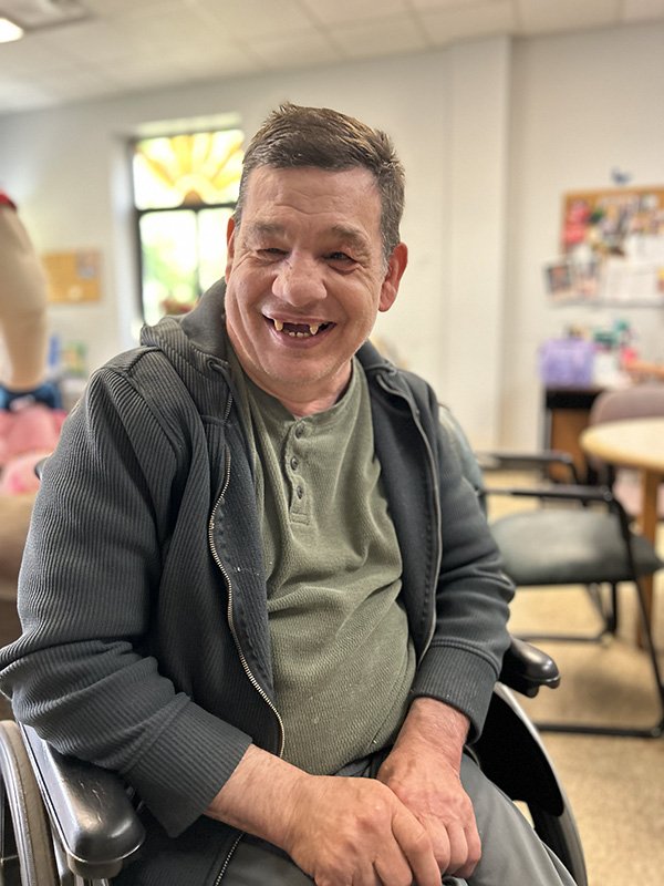 man in wheelchair smiling at camera