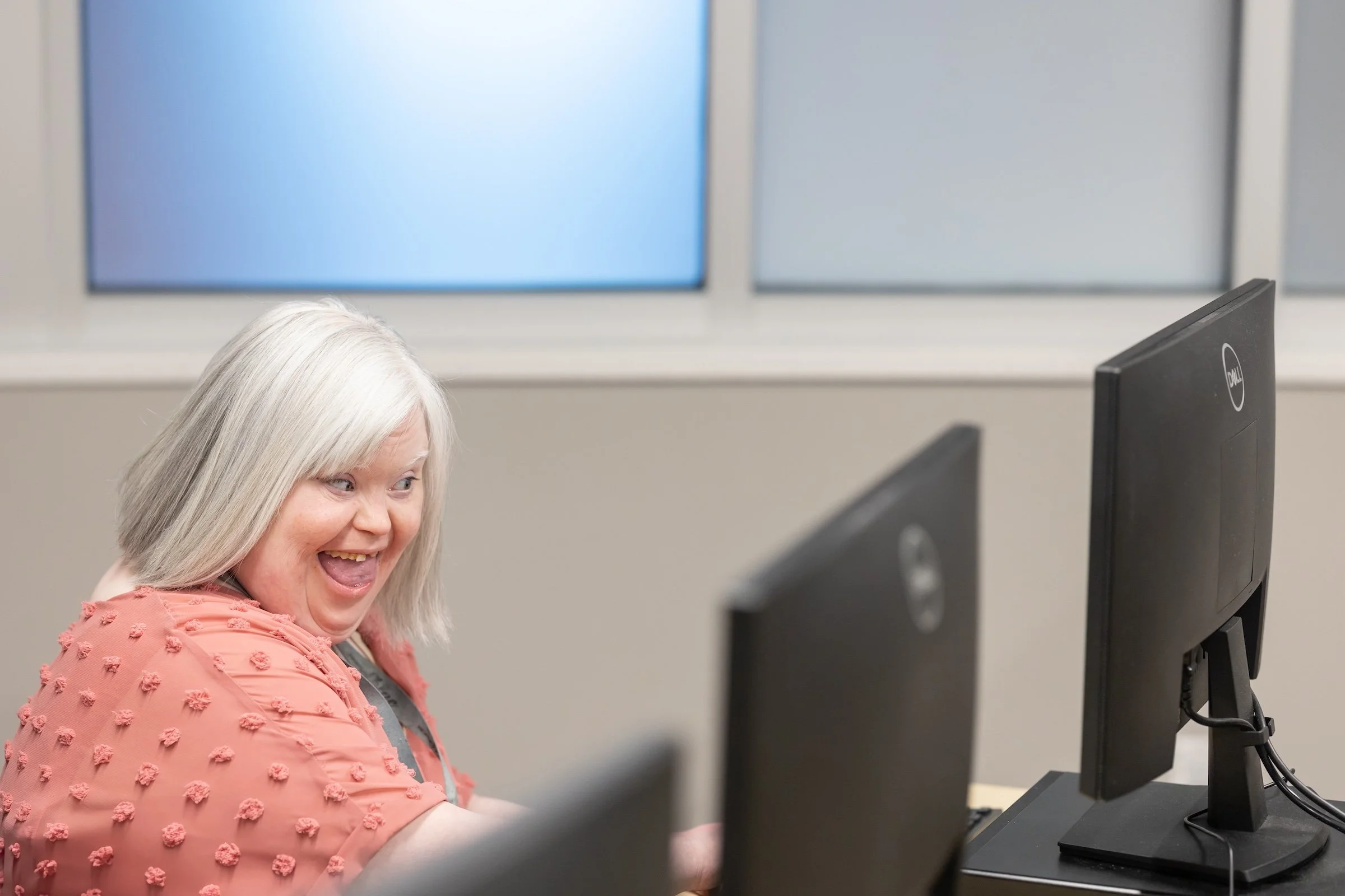 smiling using the computer lab at The Arc of Washington County