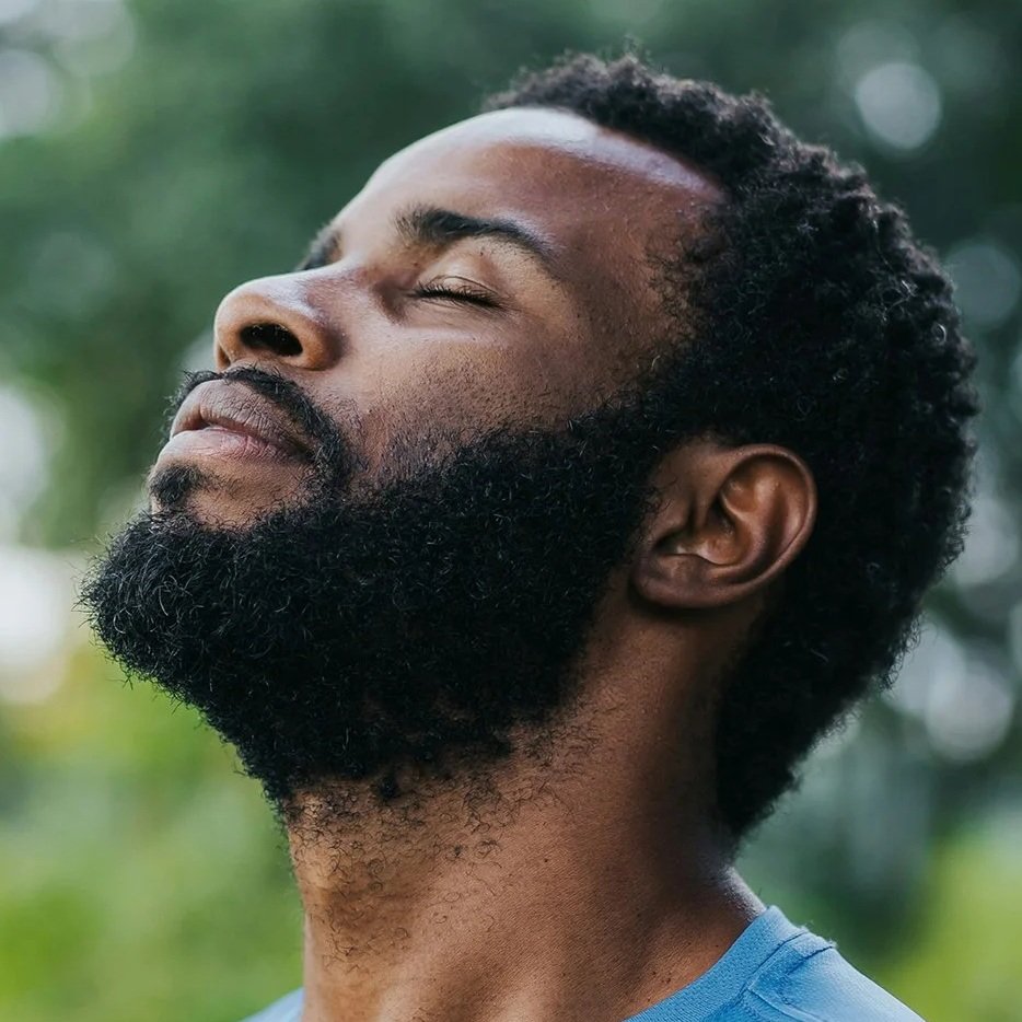 man in blue shirt looking up with eyes closed