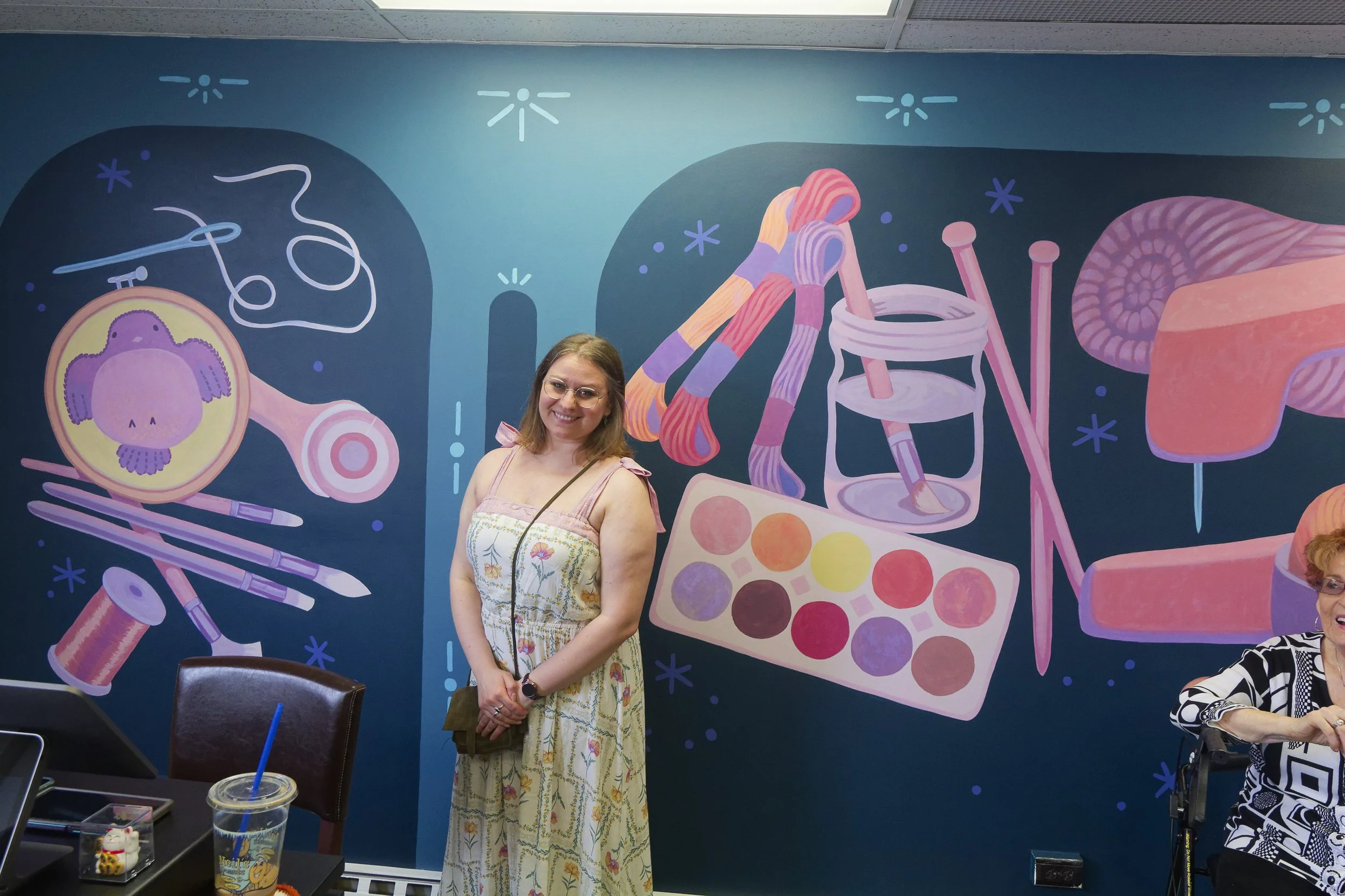 Local artist posing with her mural masterpiece!