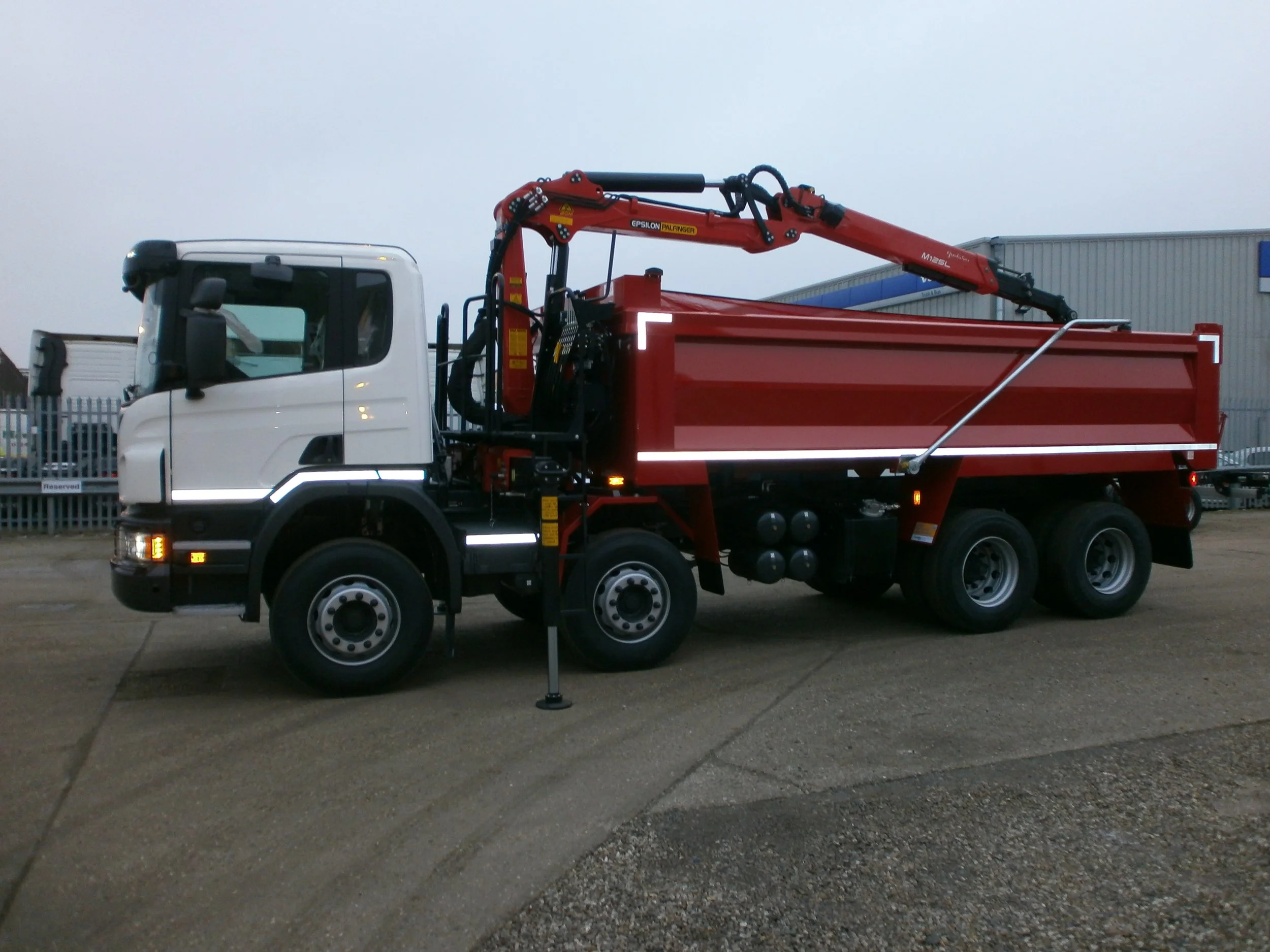 A fire truck with a crane arm parked outside on a concrete surface.