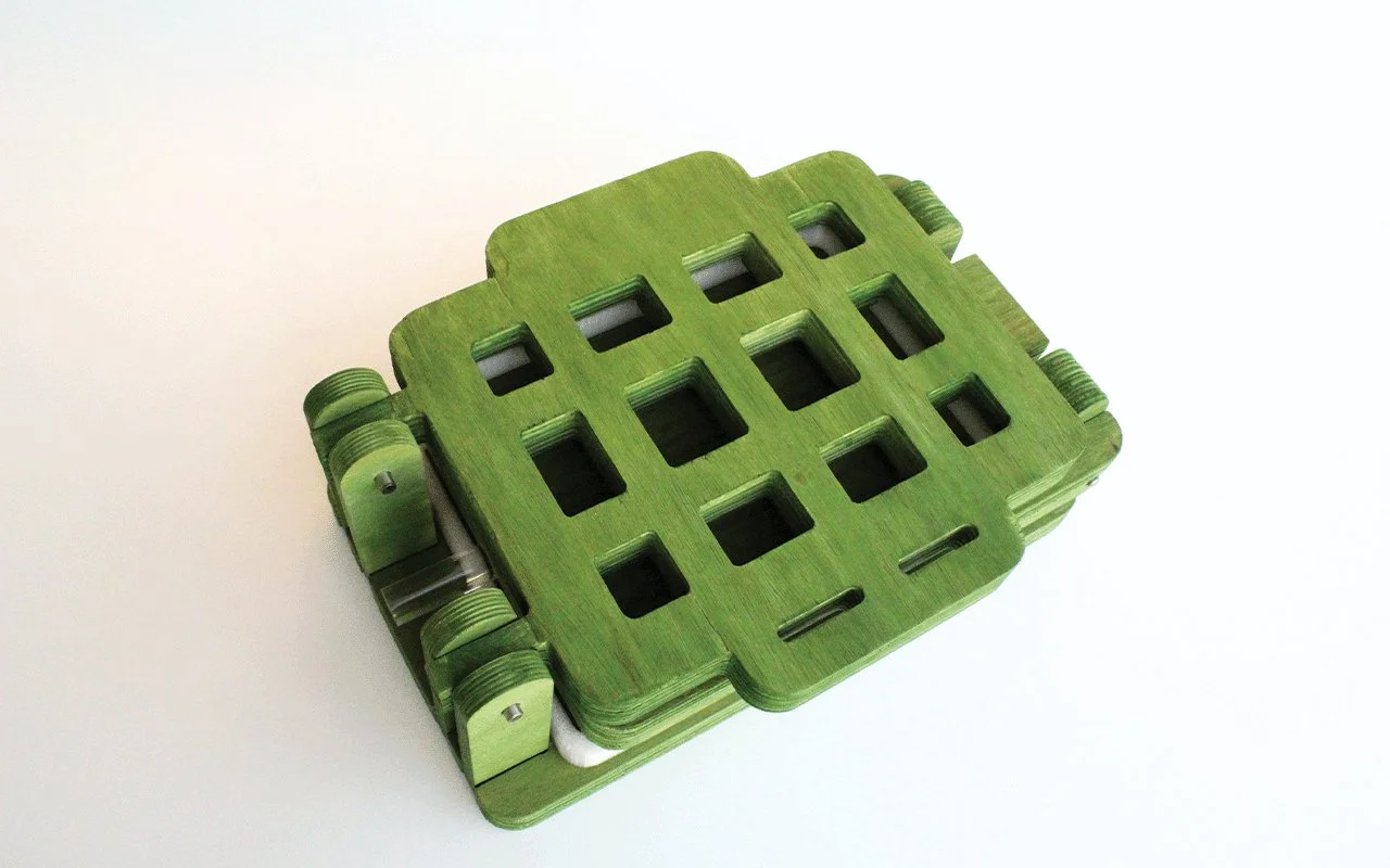  This physical prototype demonstrates the final form of the embossing device. Crafted from plywood and stained green to reflect a cohesive visual identity, the design incorporates an acrylic handle to introduce tactile contrast. The combination of ma