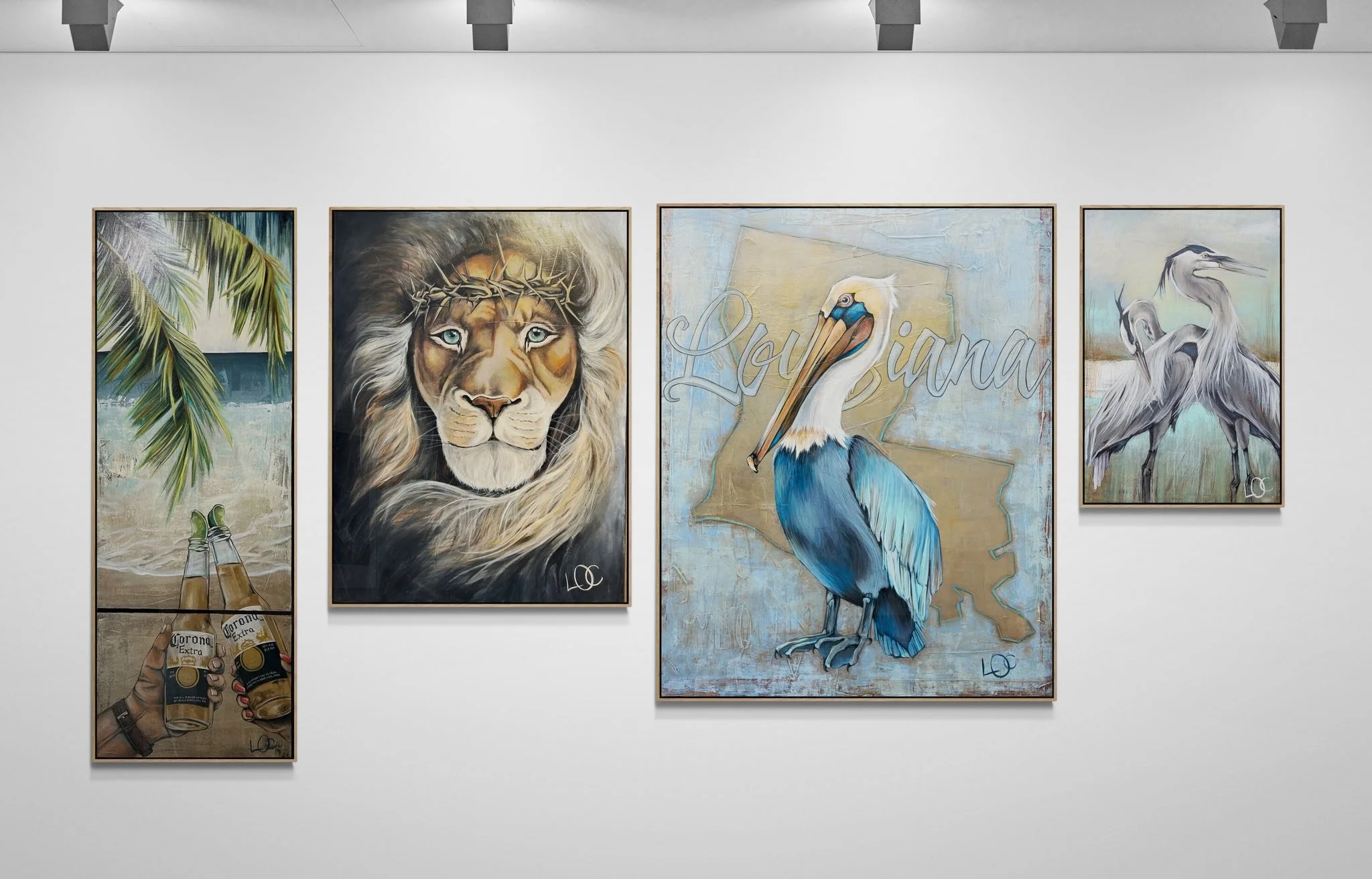 A gallery wall showcasing four framed paintings with a tropical, wildlife, and urban theme. The first painting depicts palm leaves and beach scene; the second features a lion with a crown of thorns; the third shows a colorful pelican with the word "Louisiana" in the background; the fourth portrays a heron standing on water.