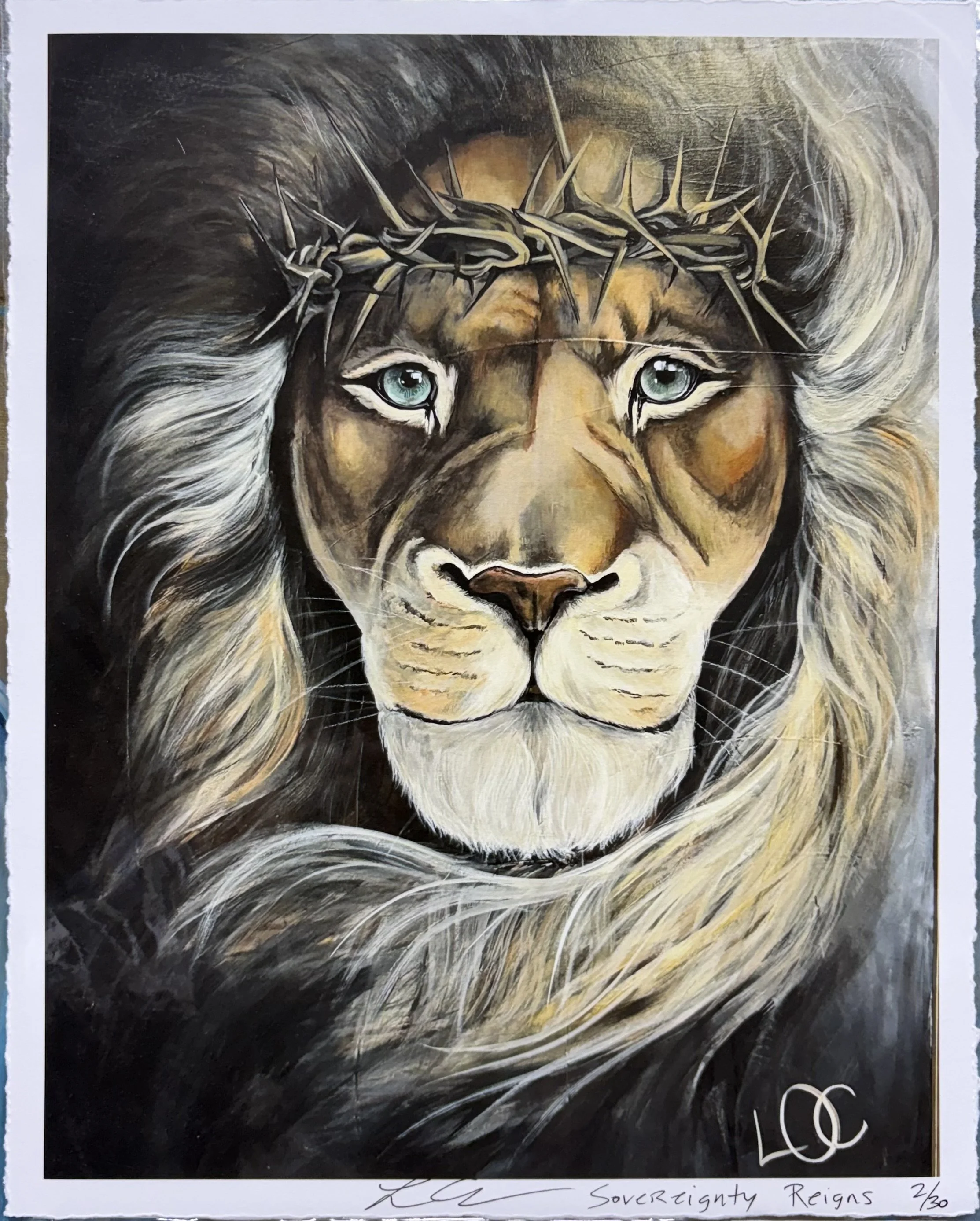 Painting of a lion with piercing blue eyes, wearing a crown made of thorns. The background is dark and swirling with shades of black, gray, and white. There is a signature at the bottom left and handwritten text at the bottom right that reads 'Sovereignty Reigns 2/30'.