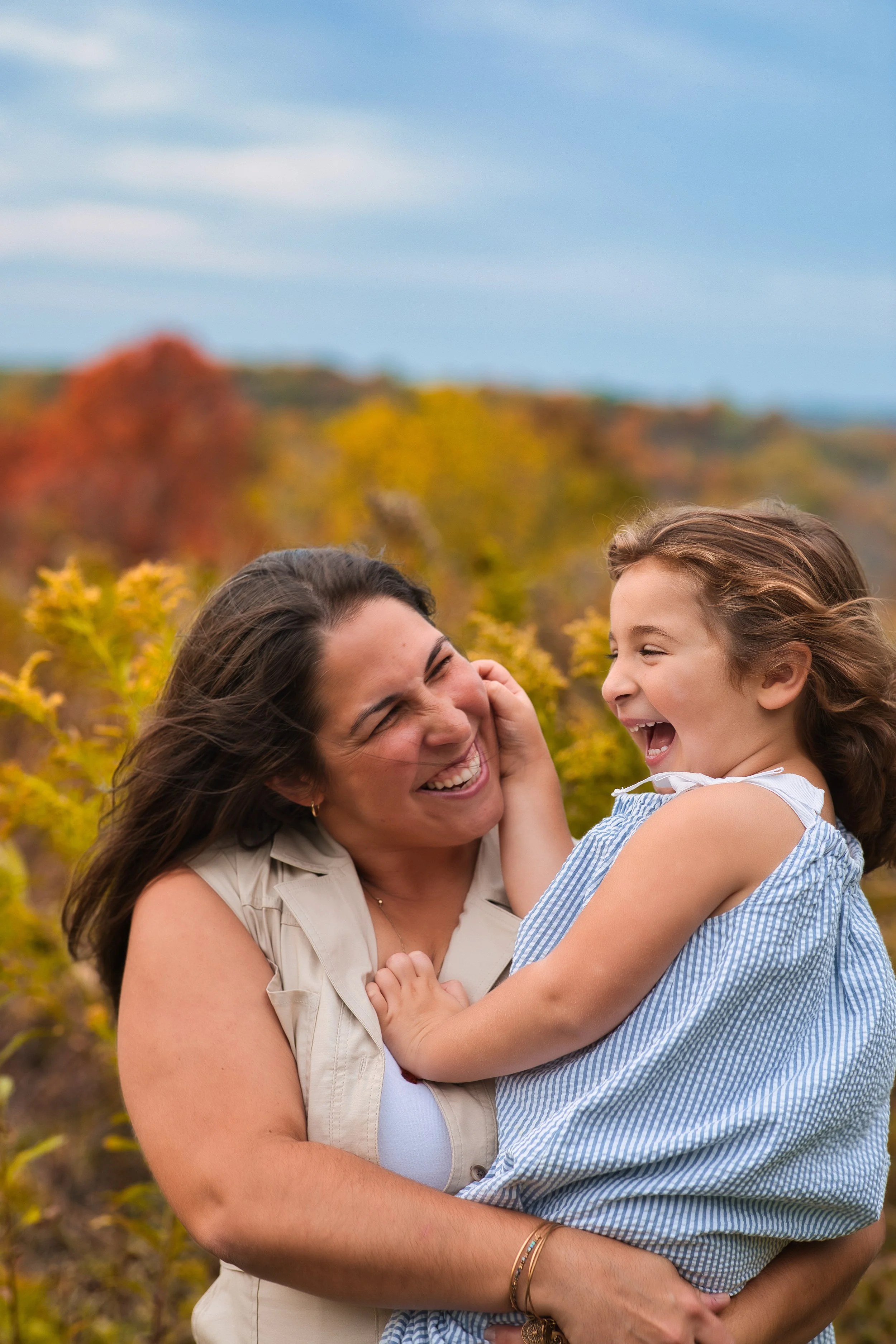 Rochester, NY candid family portrait of a mother and daughter laughing together outdoors