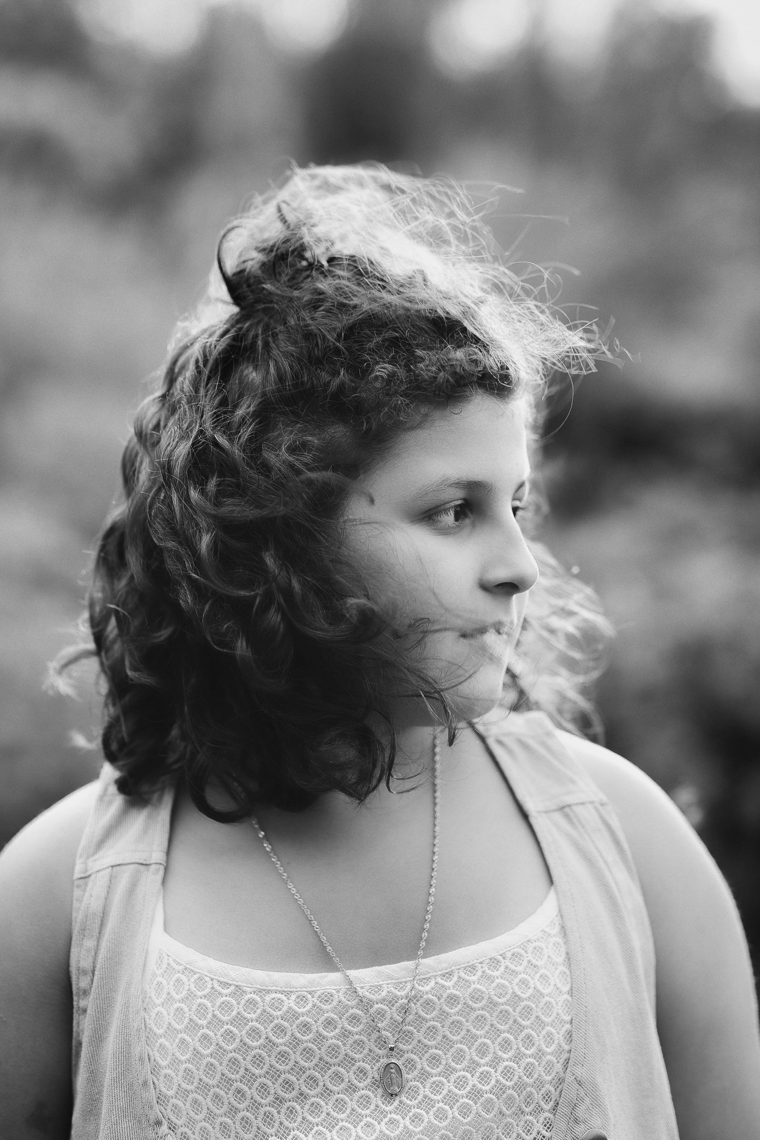 Rochester, NY black and white portrait of a young girl with curly hair looking to the side outdoors