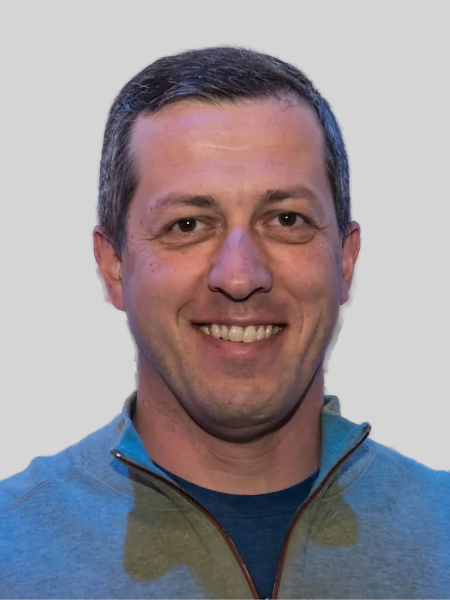 Man smiling in front of textured wall