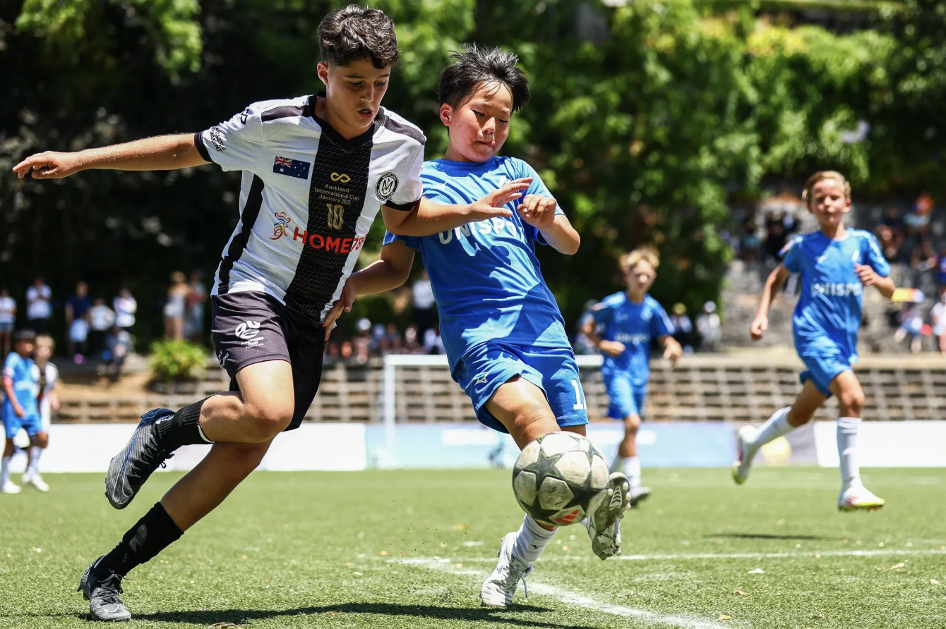 Children playing soccer on a field, competing for the ball during a game.
