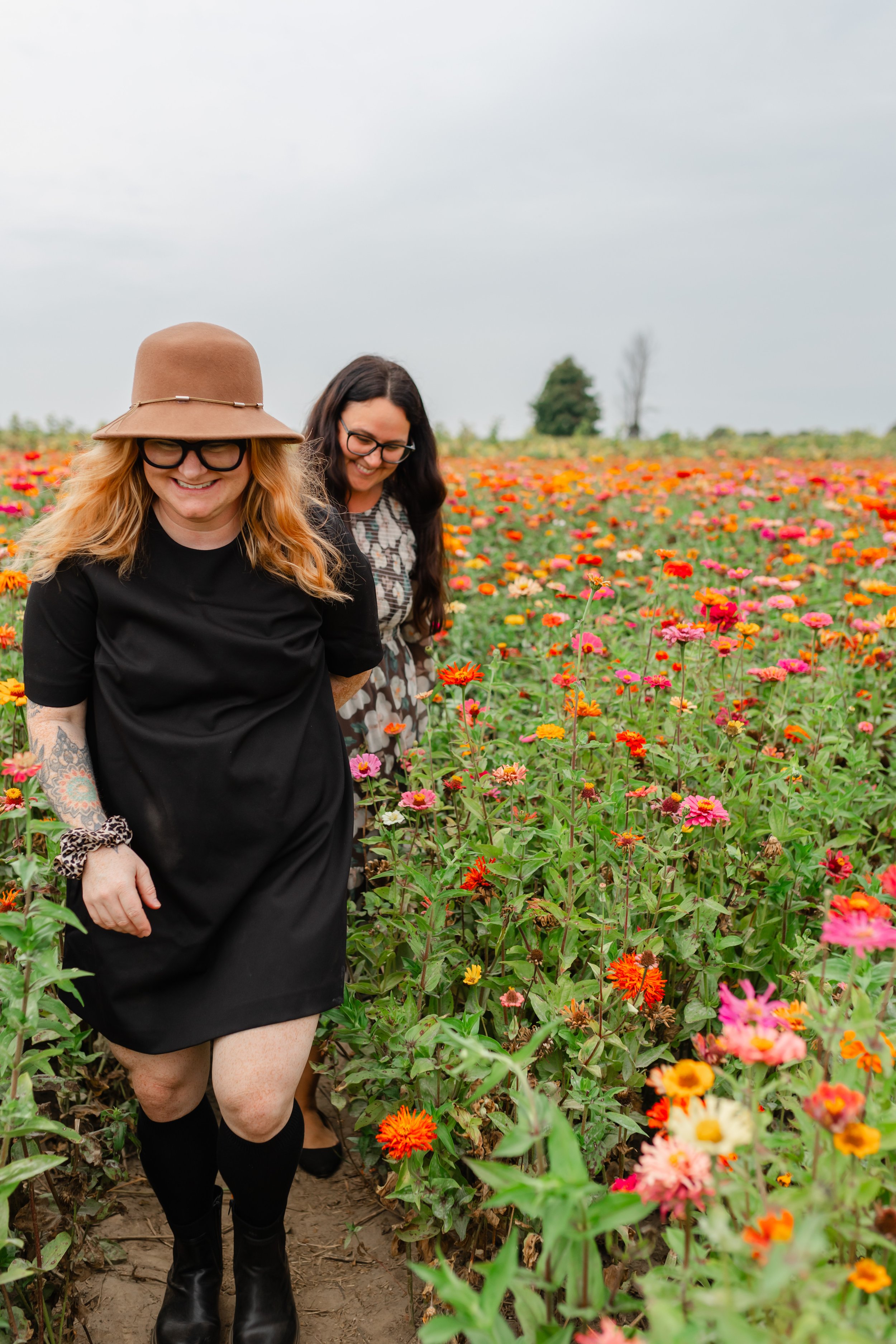 Two women walking through a colorful flower field