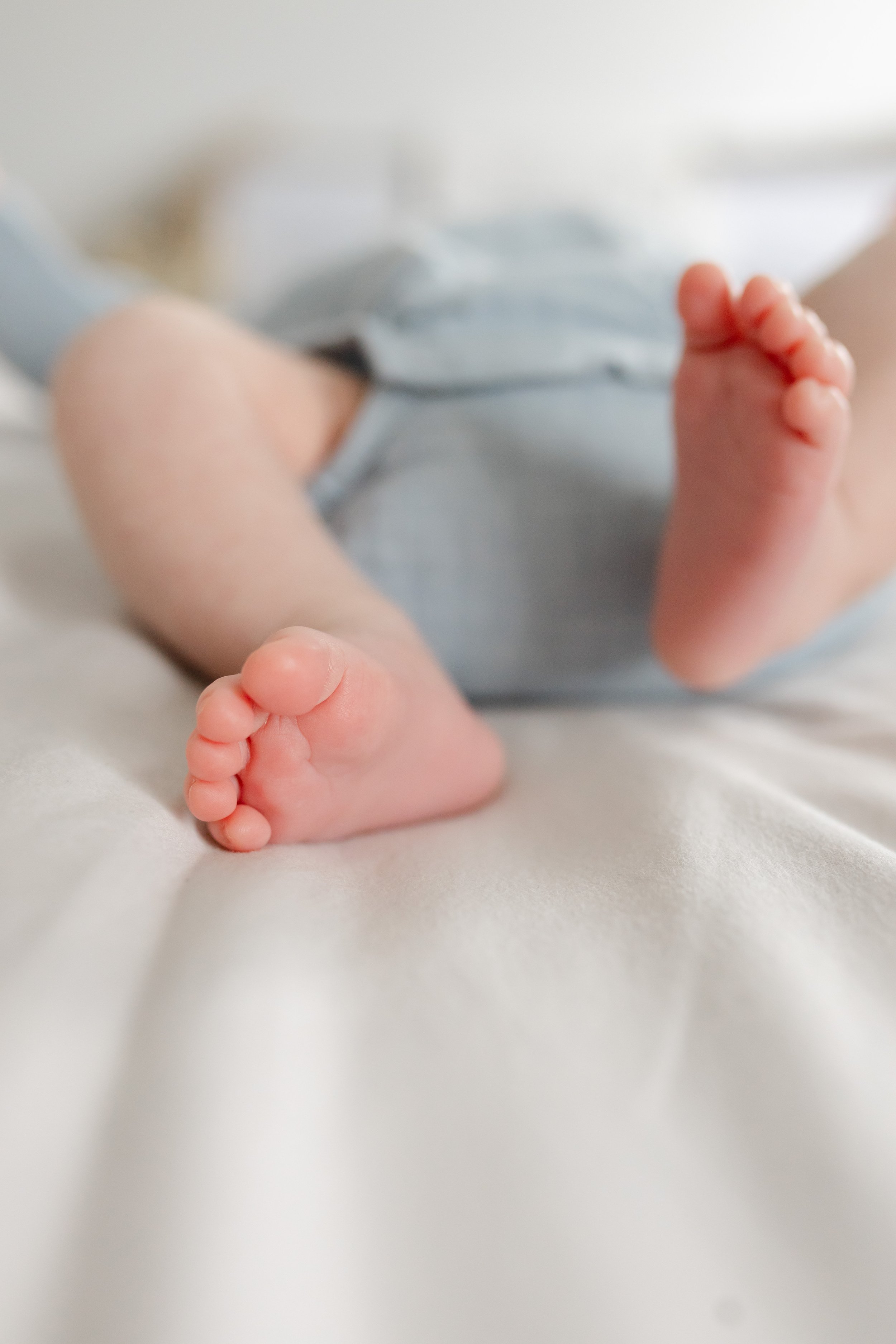 Close-up of a baby's feet lying on a bed.