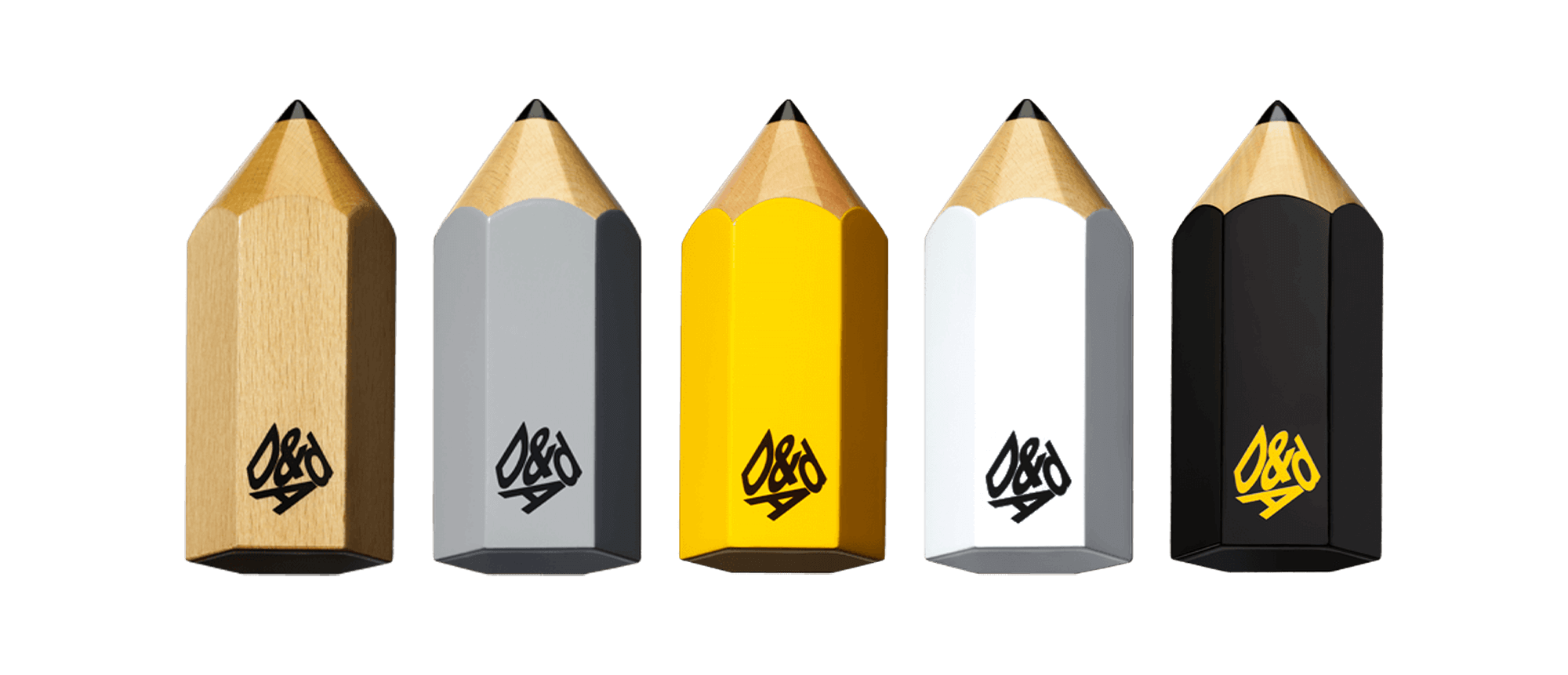 Five pencil-shaped awards in wood, gray, yellow, white, and black, each with a logo that appears to say 'D&AD' in stylized lettering.