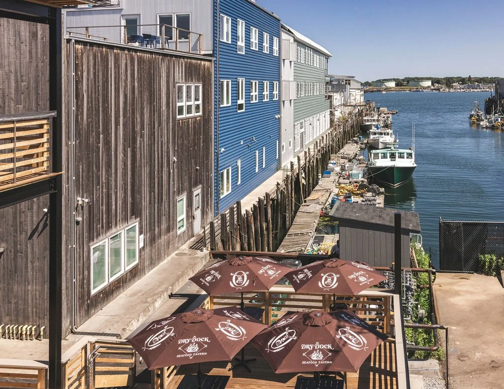 View of Dry Dock outdoor seating with waterfront view and brown umbrellas