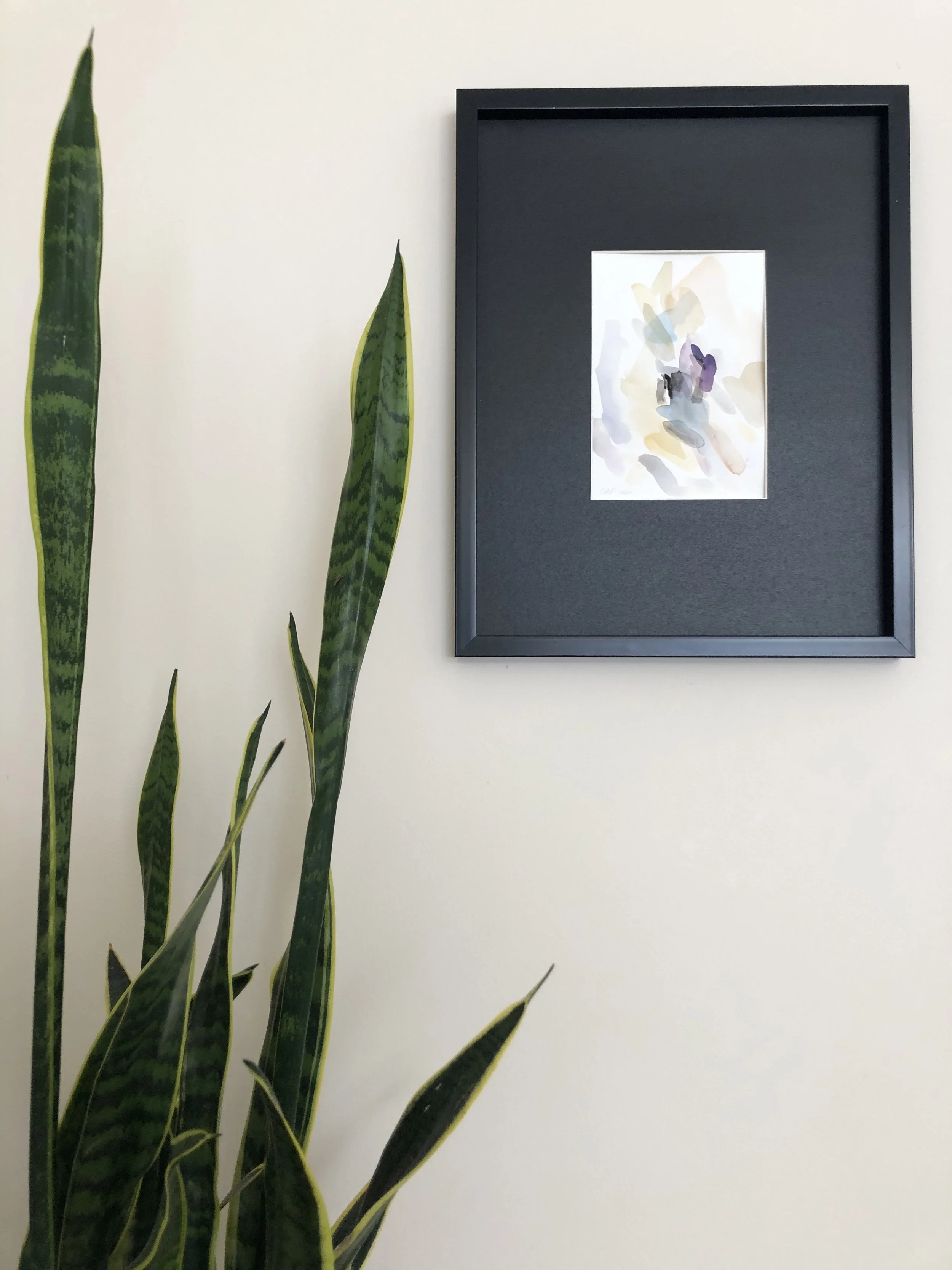 An abstract gouache artwork painted in soothing neutral hues, with flowing shapes and layered textures that create a sense of calm, balance, and natural warmth, framed in a modern black frame